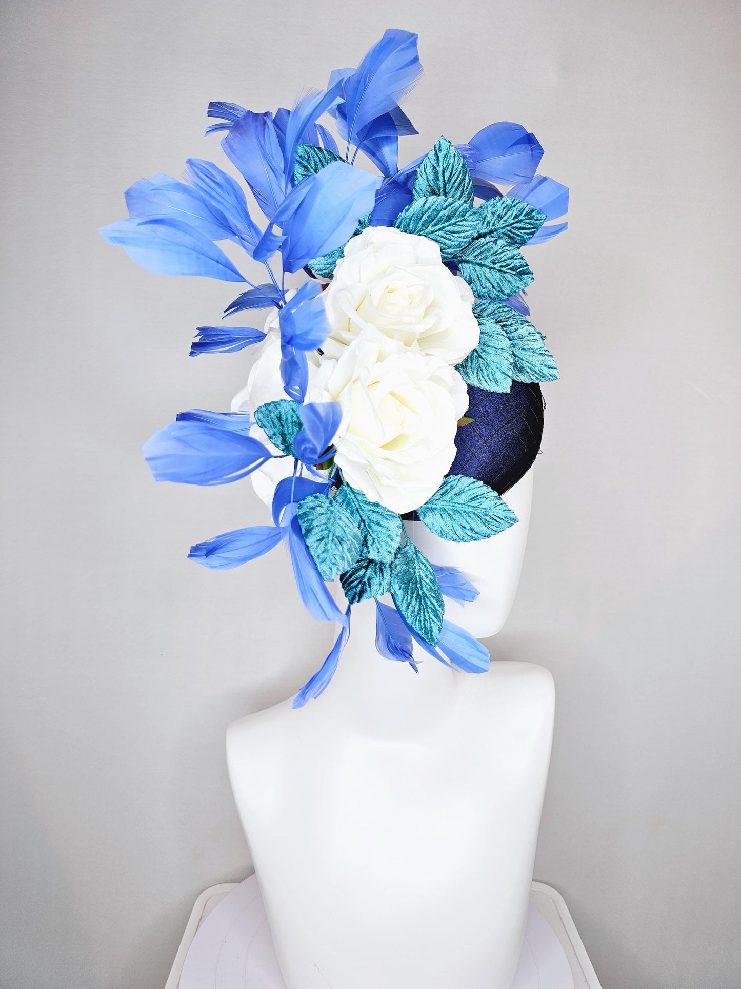 kentucky derby hat fascinator midnight navy blue satin with white silk flowers,teal blue velvet leaves,and royal blue branching feathers