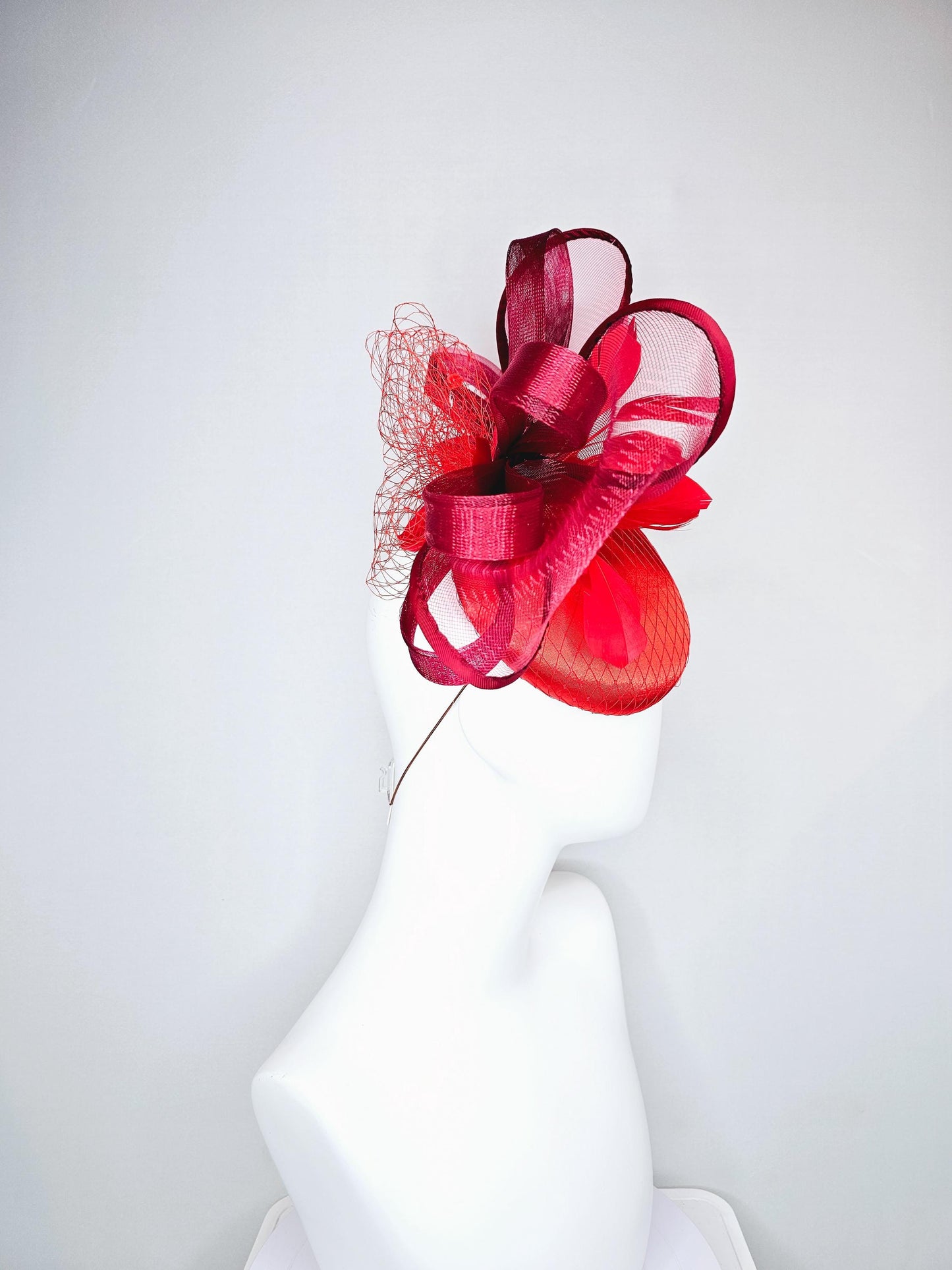 kentucky derby hat fascinator cherry red satin with netting,branching bright red feathers and large mesh burgundy wine bow