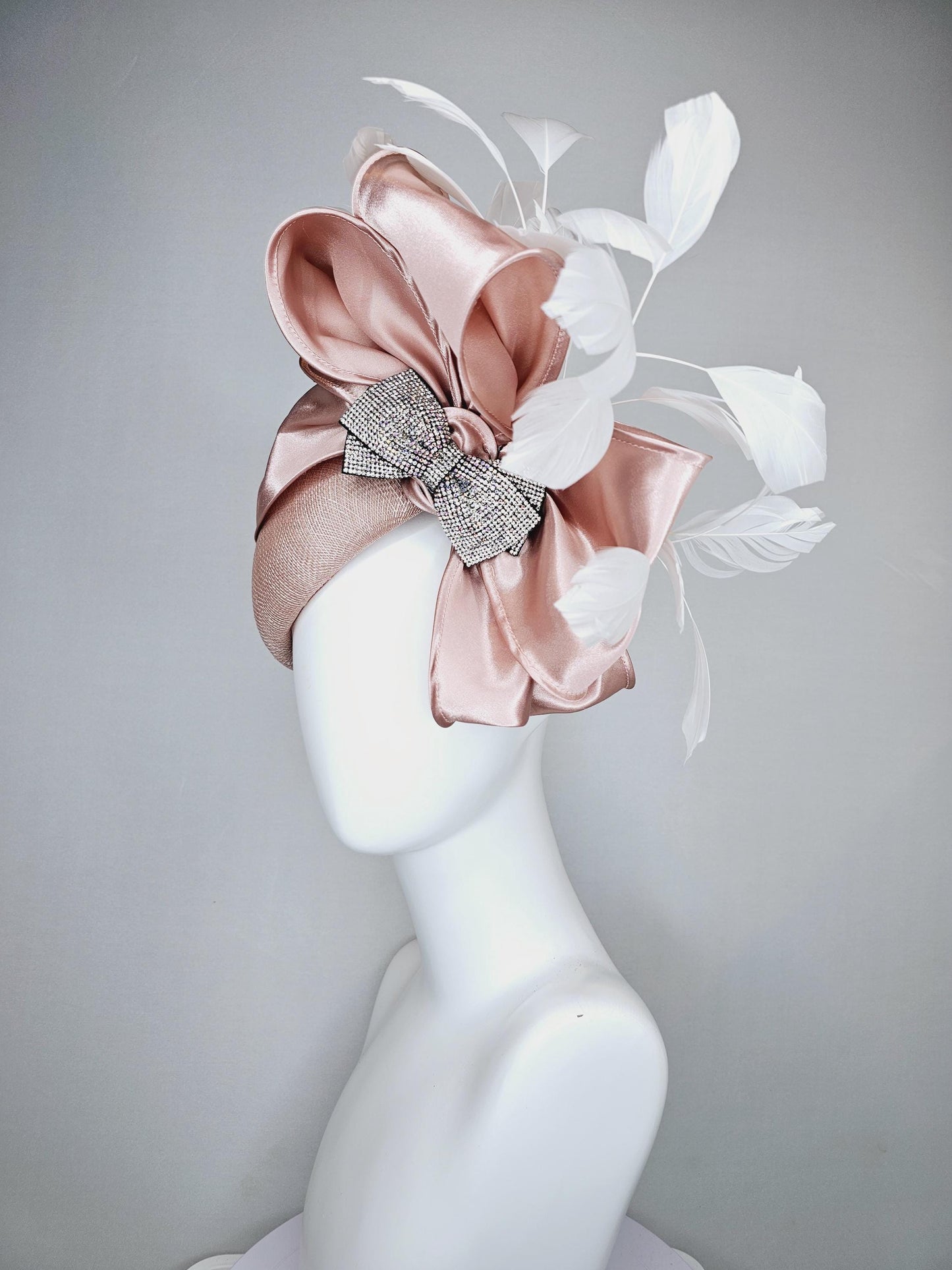 kentucky derby hat fascinator light dusty pink sinamay with satin champagne pink bow with Swarovski crystal bow and branching white feather