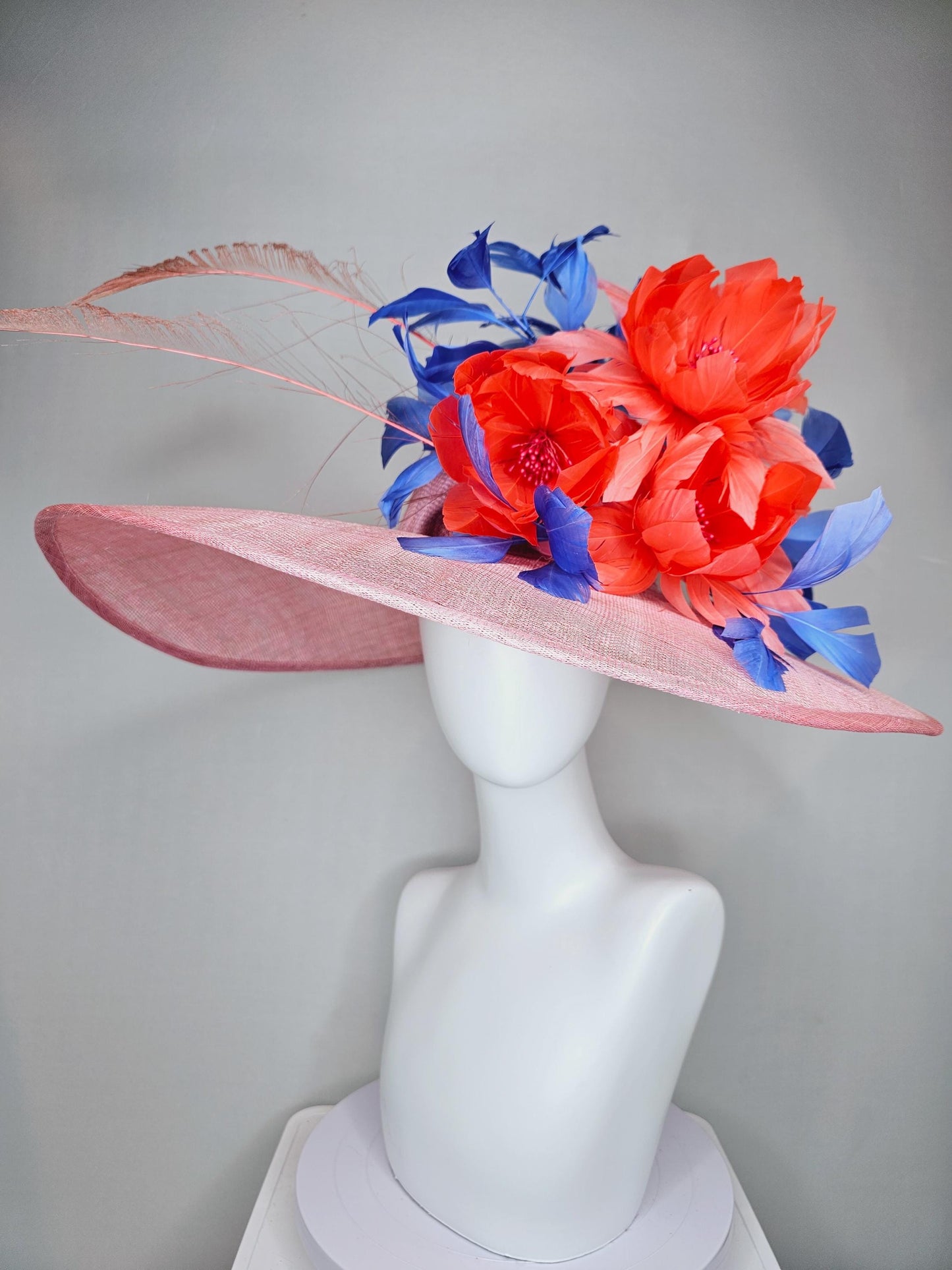 kentucky derby hat large wide brim sinamay blush pink hat with large orange coral feather flowers and royal blue branching feathers