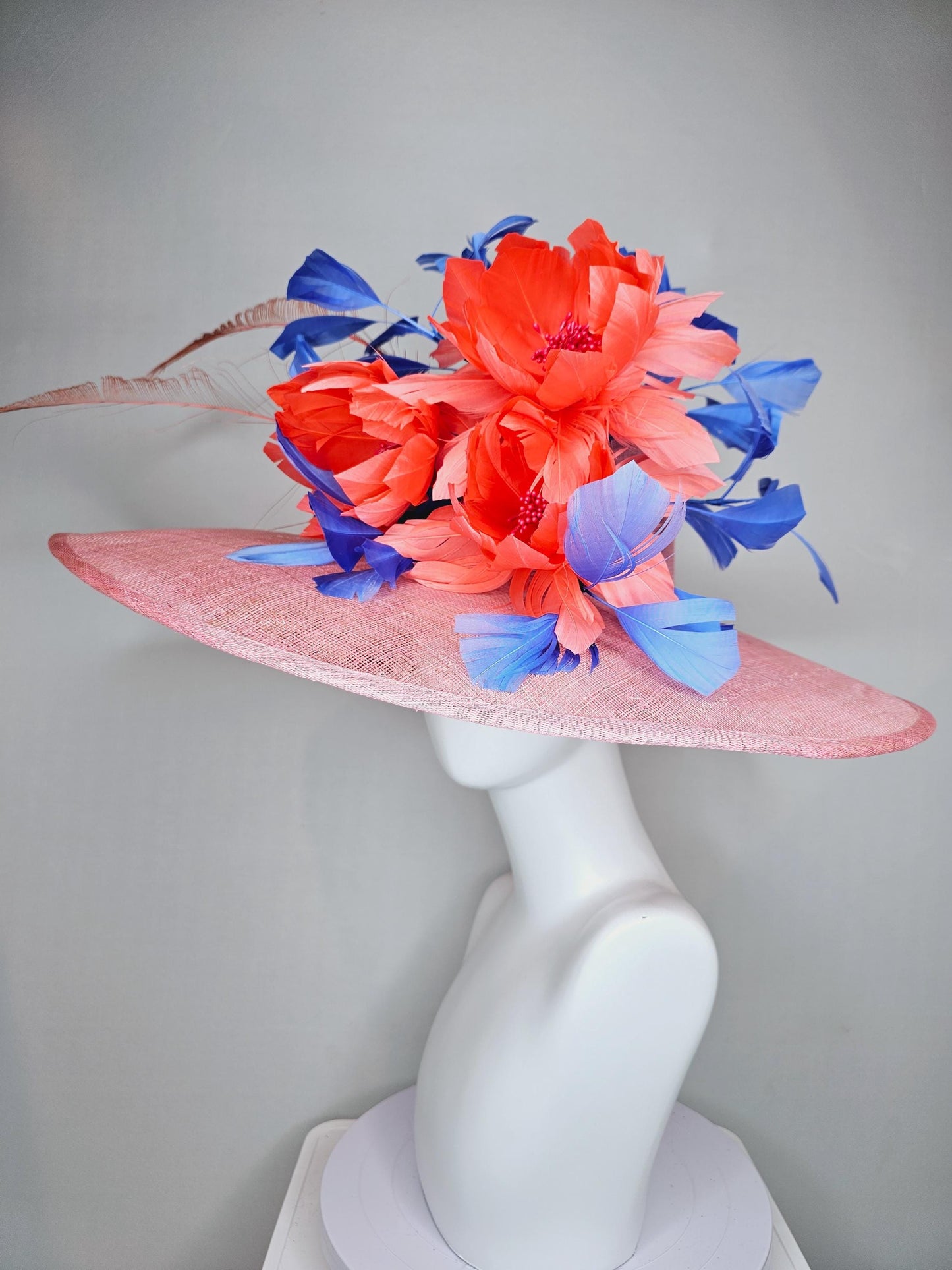 kentucky derby hat large wide brim sinamay blush pink hat with large orange coral feather flowers and royal blue branching feathers