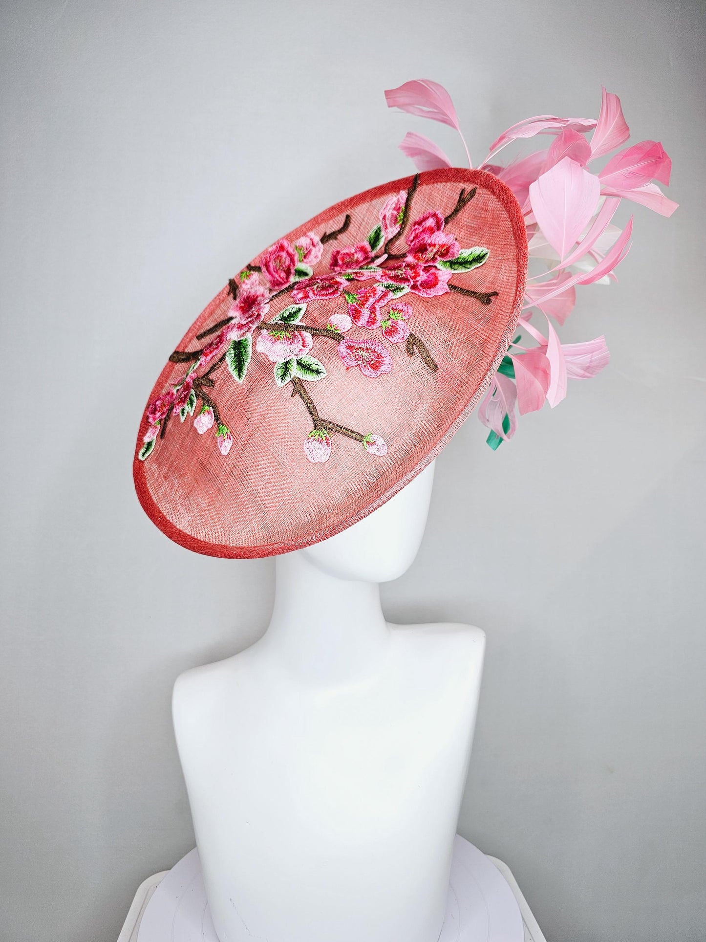 kentucky derby hat fascinator coral peach sinamay saucer with pink green brown floral embroidery,light pink and green branching feathers