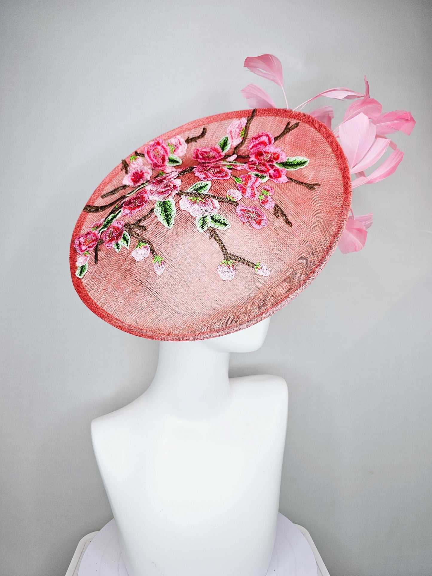 kentucky derby hat fascinator coral peach sinamay saucer with pink green brown floral embroidery,light pink and green branching feathers