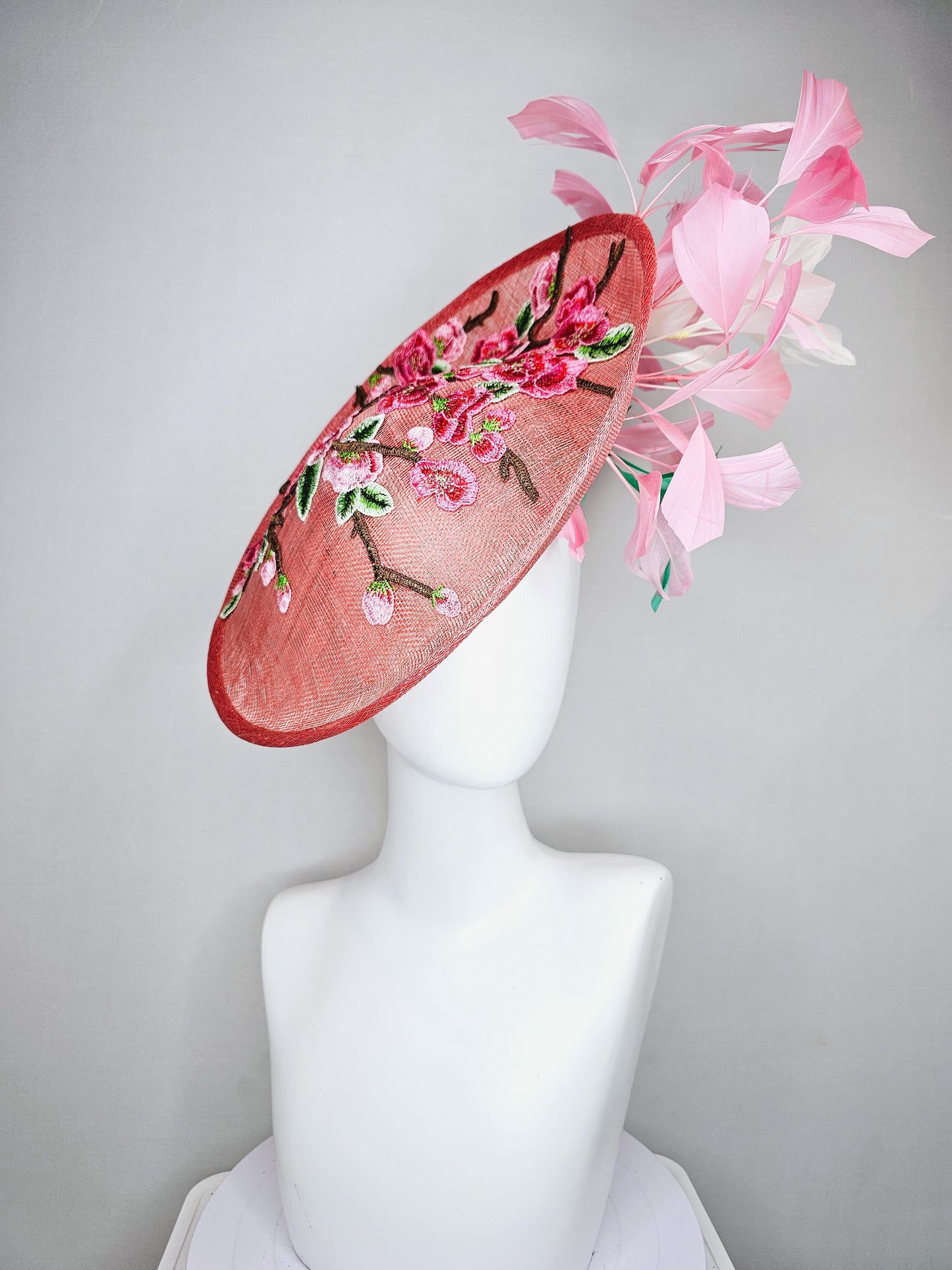 kentucky derby hat fascinator coral peach sinamay saucer with pink green brown floral embroidery,light pink and green branching feathers