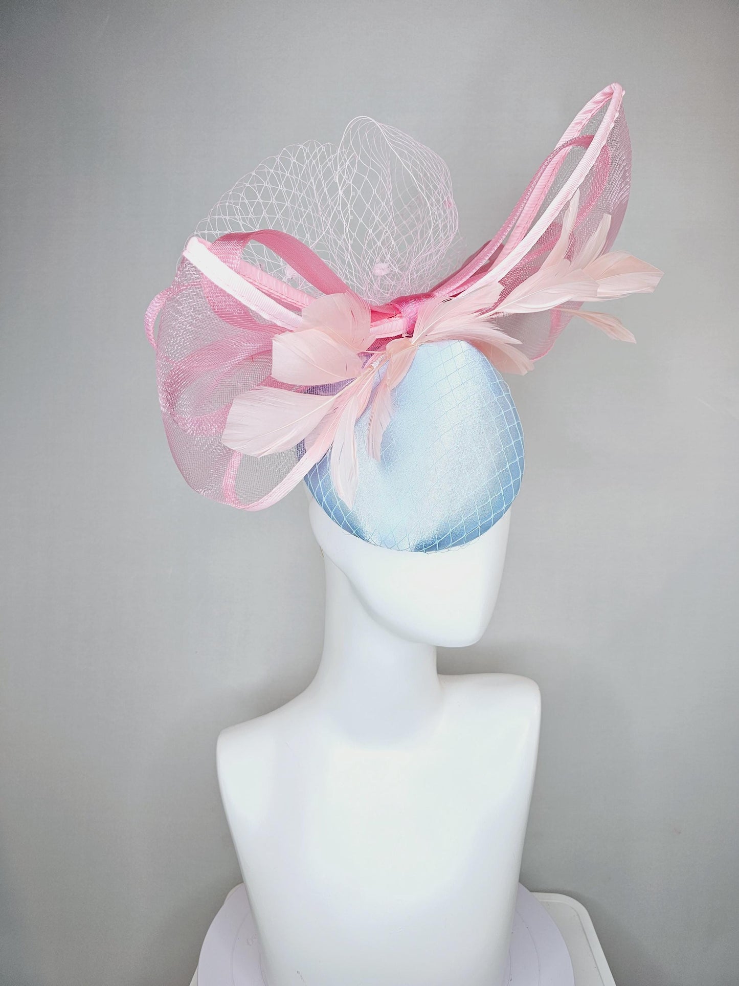 kentucky derby hat fascinator light baby blue satin with netting, branching light blush pink feathers and large mesh blush pink bow