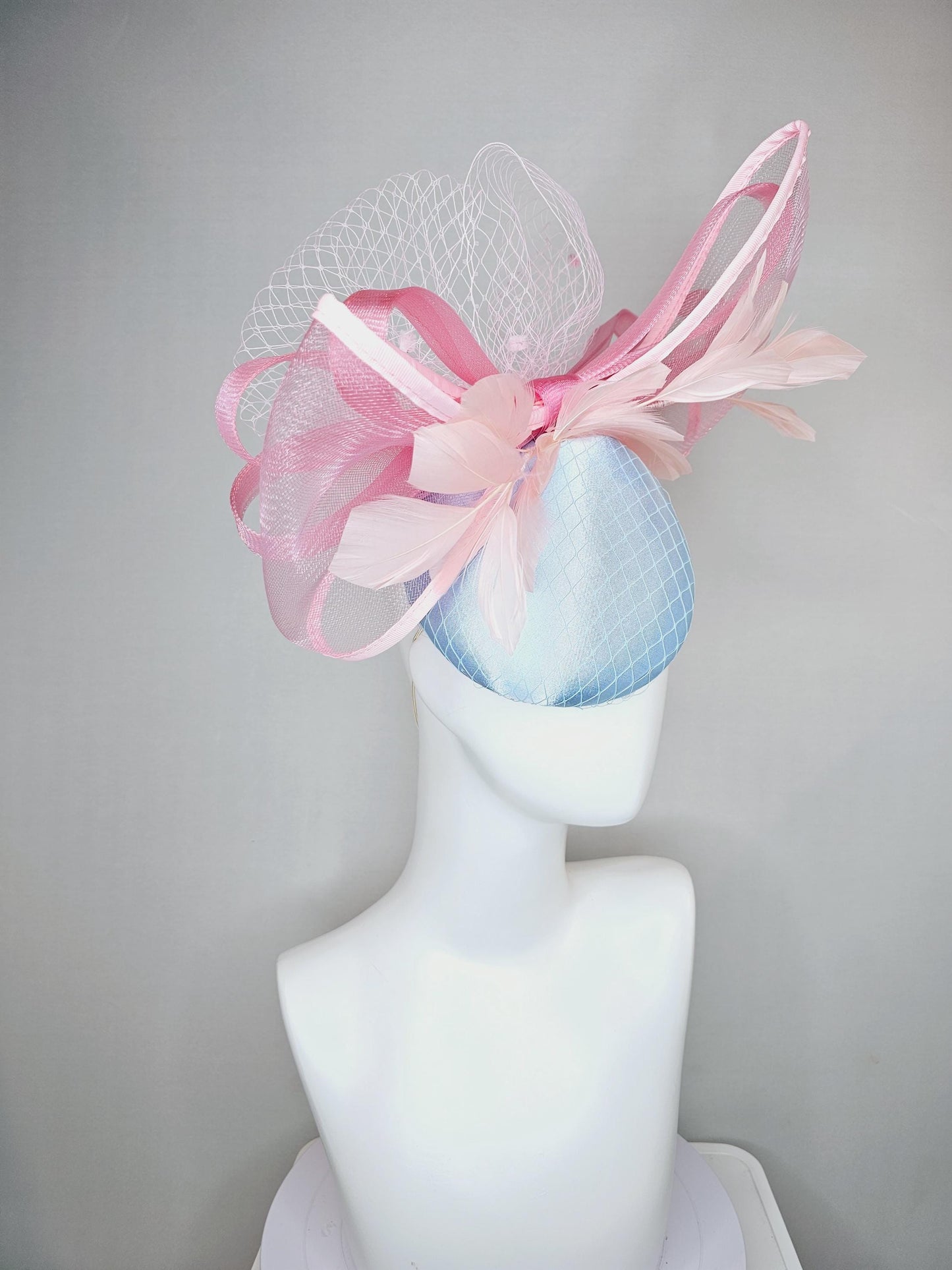 kentucky derby hat fascinator light baby blue satin with netting, branching light blush pink feathers and large mesh blush pink bow