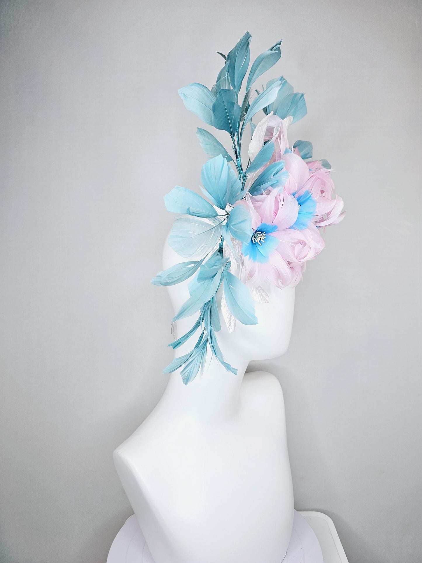 kentucky derby hat fascinator with pale pink feather flowers with sky blue feather cores, white leaves and teal blue branching feathers