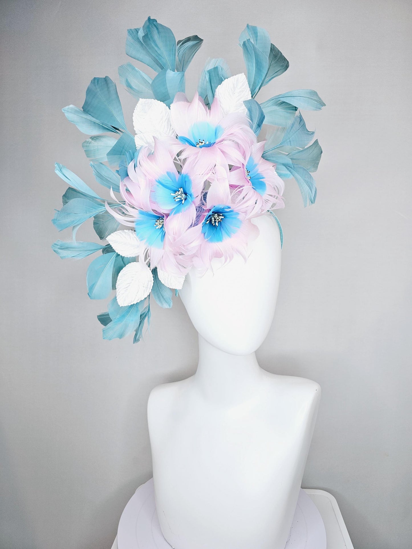 kentucky derby hat fascinator with pale pink feather flowers with sky blue feather cores, white leaves and teal blue branching feathers