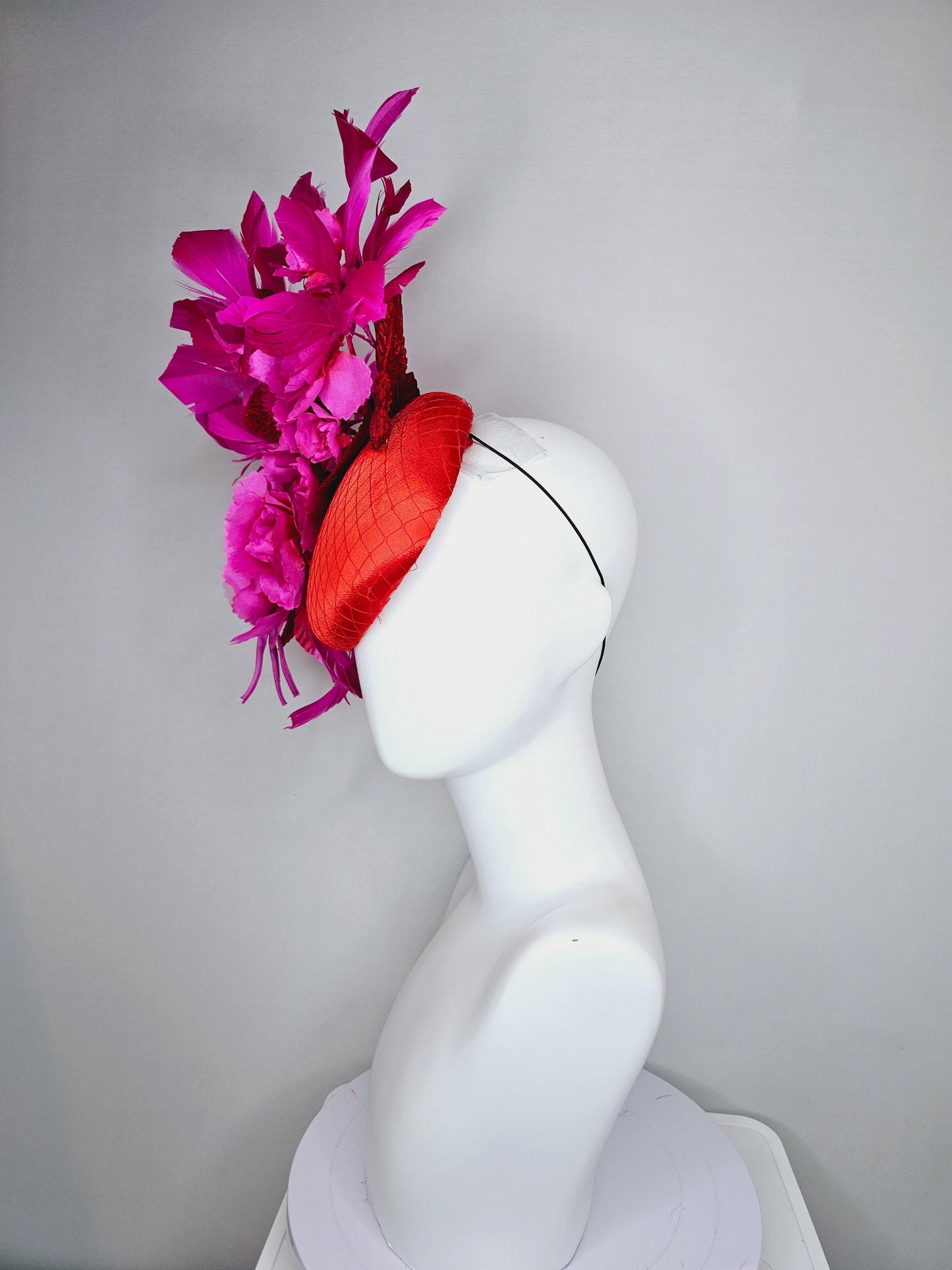 kentucky derby hat fascinator red satin with netting,bright pink fuchsia satin flowers, scarlet red leaves, bright pink branching feathers