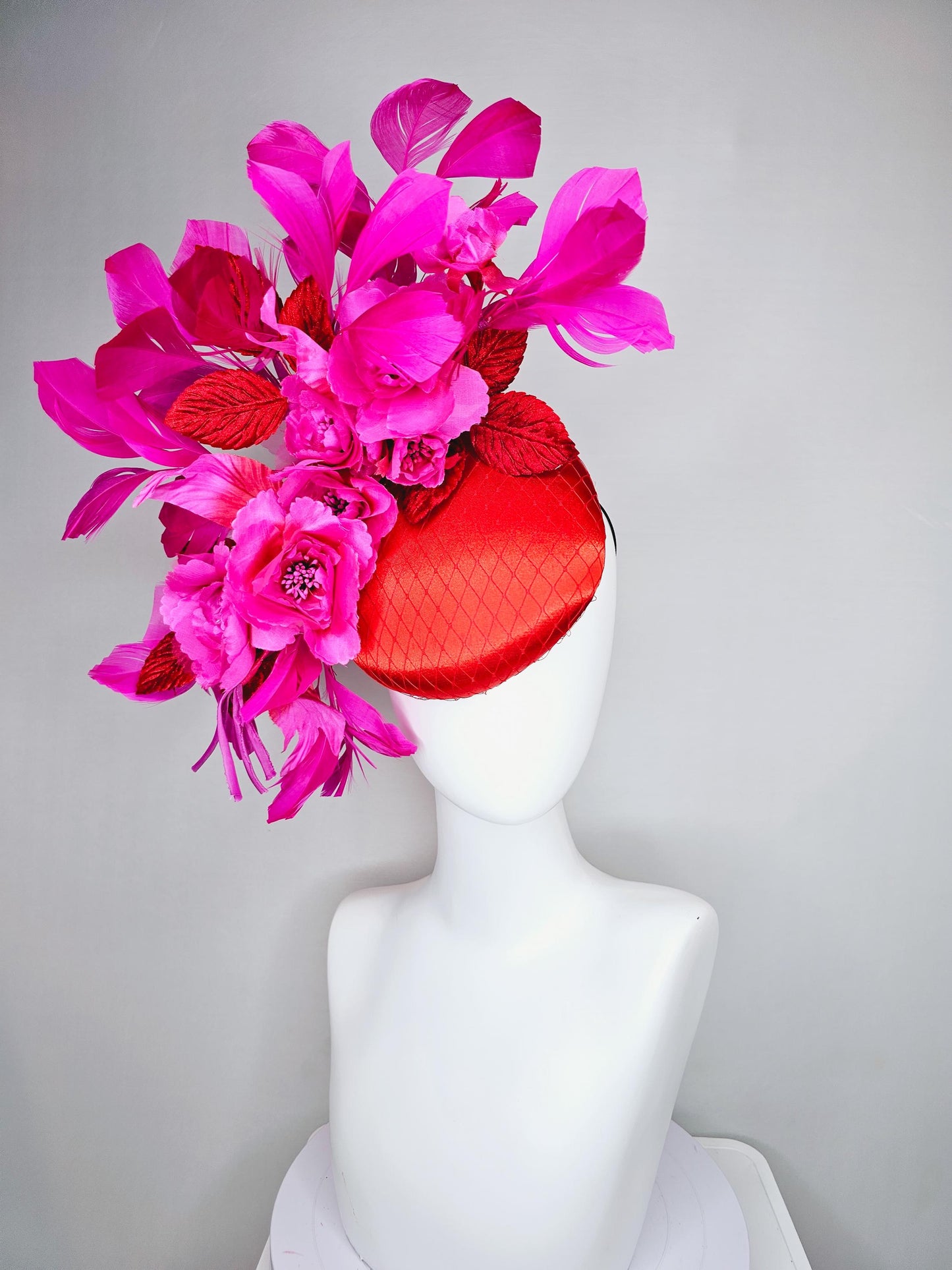 kentucky derby hat fascinator red satin with netting,bright pink fuchsia satin flowers, scarlet red leaves, bright pink branching feathers