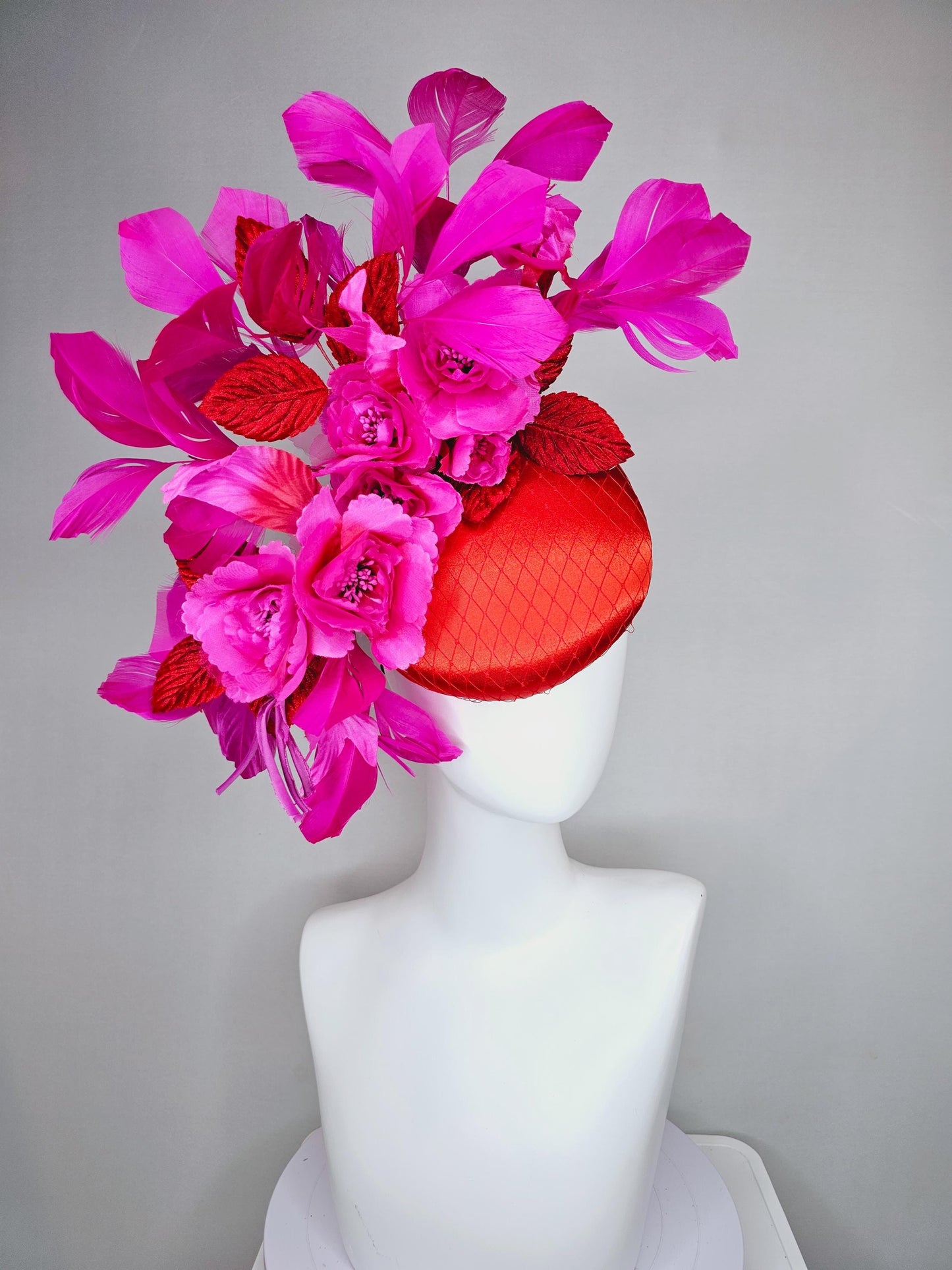 kentucky derby hat fascinator red satin with netting,bright pink fuchsia satin flowers, scarlet red leaves, bright pink branching feathers