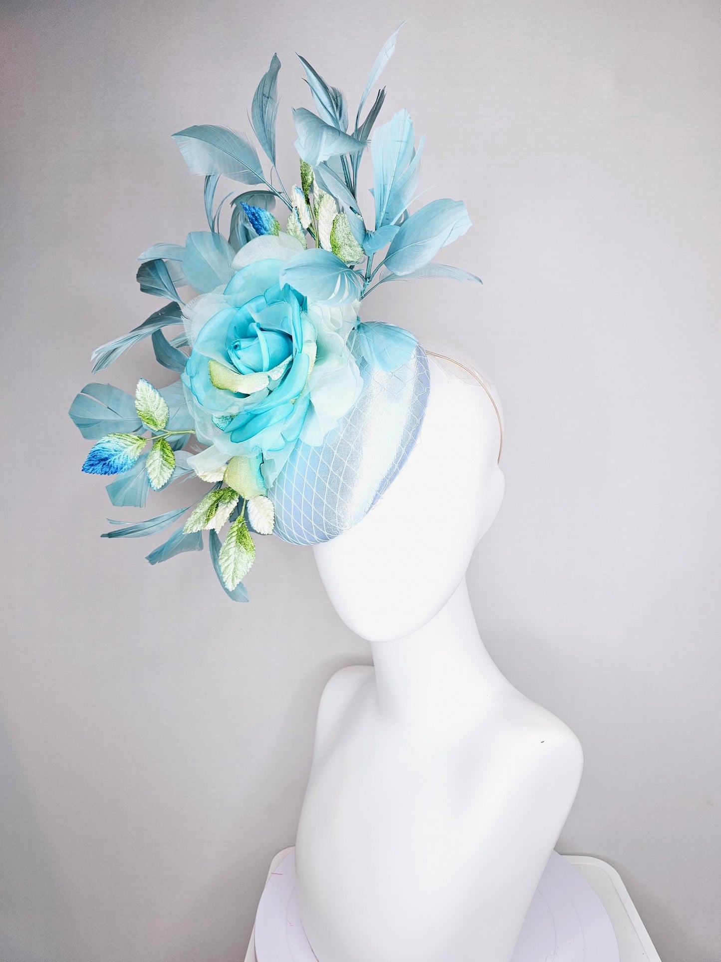 kentucky derby hat fascinator light blue satin with netting, sky blue organza rose flower,blue and green leaves,teal blue branching feathers