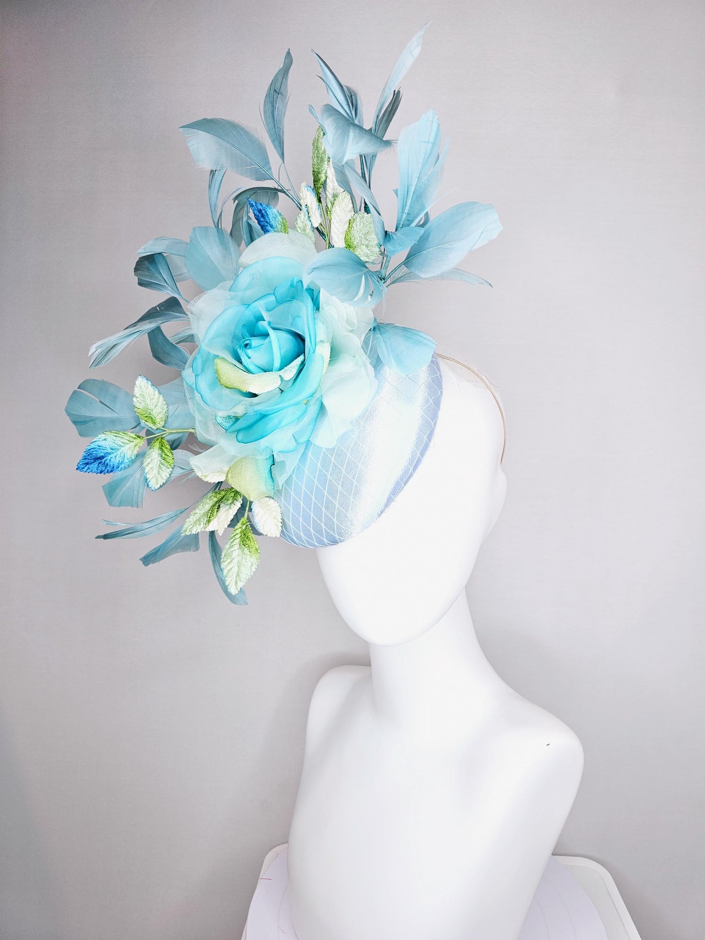 kentucky derby hat fascinator light blue satin with netting, sky blue organza rose flower,blue and green leaves,teal blue branching feathers