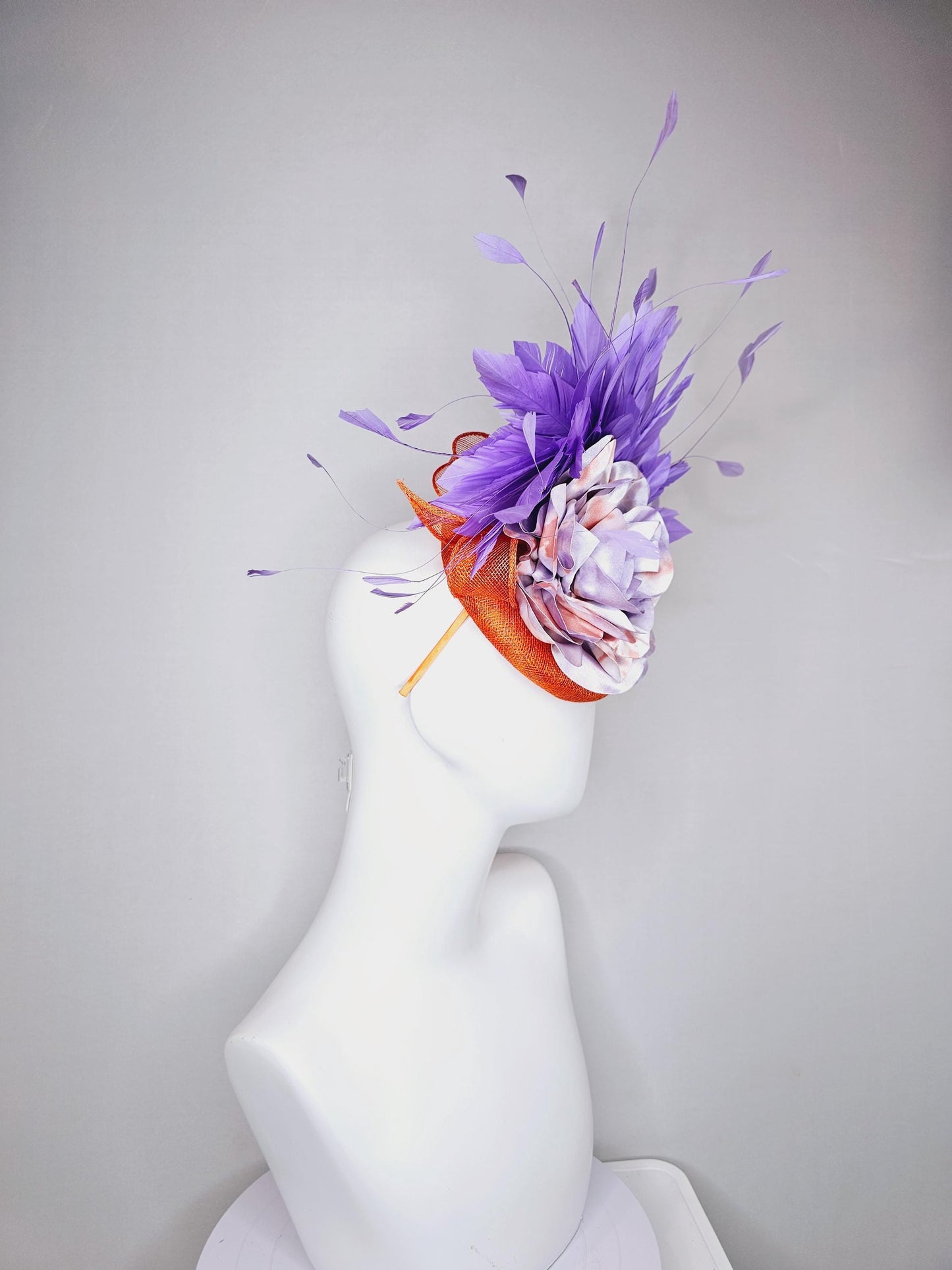 kentucky derby hat fascinator orange sinamay with lavender purple branching feathers and large purple and orange tie dye satin rose flower