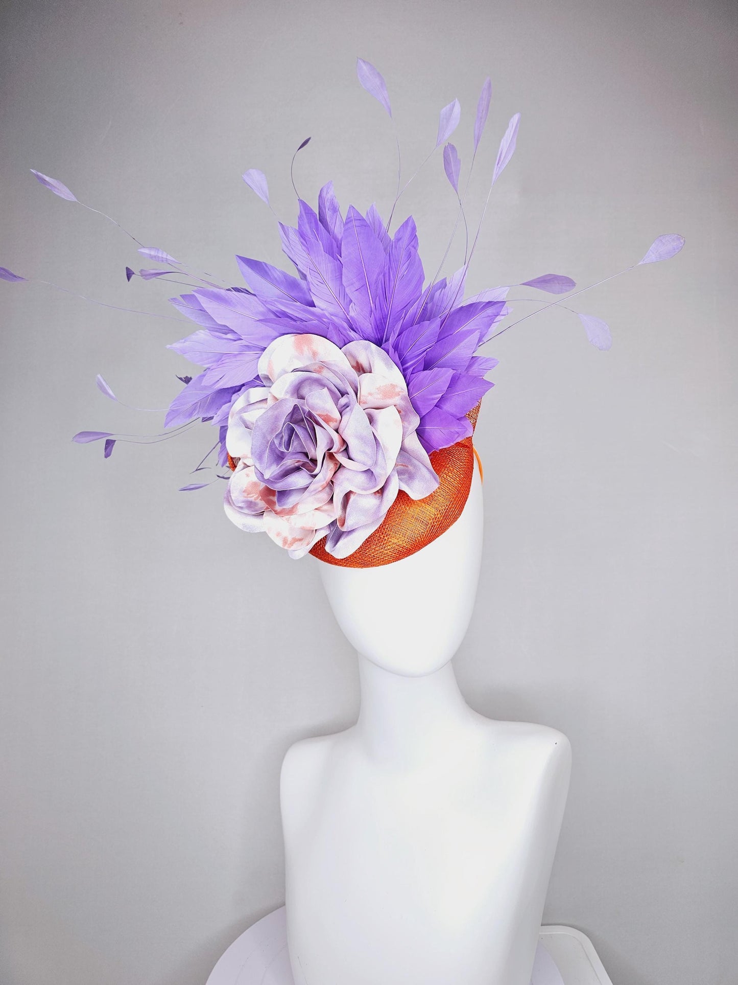 kentucky derby hat fascinator orange sinamay with lavender purple branching feathers and large purple and orange tie dye satin rose flower