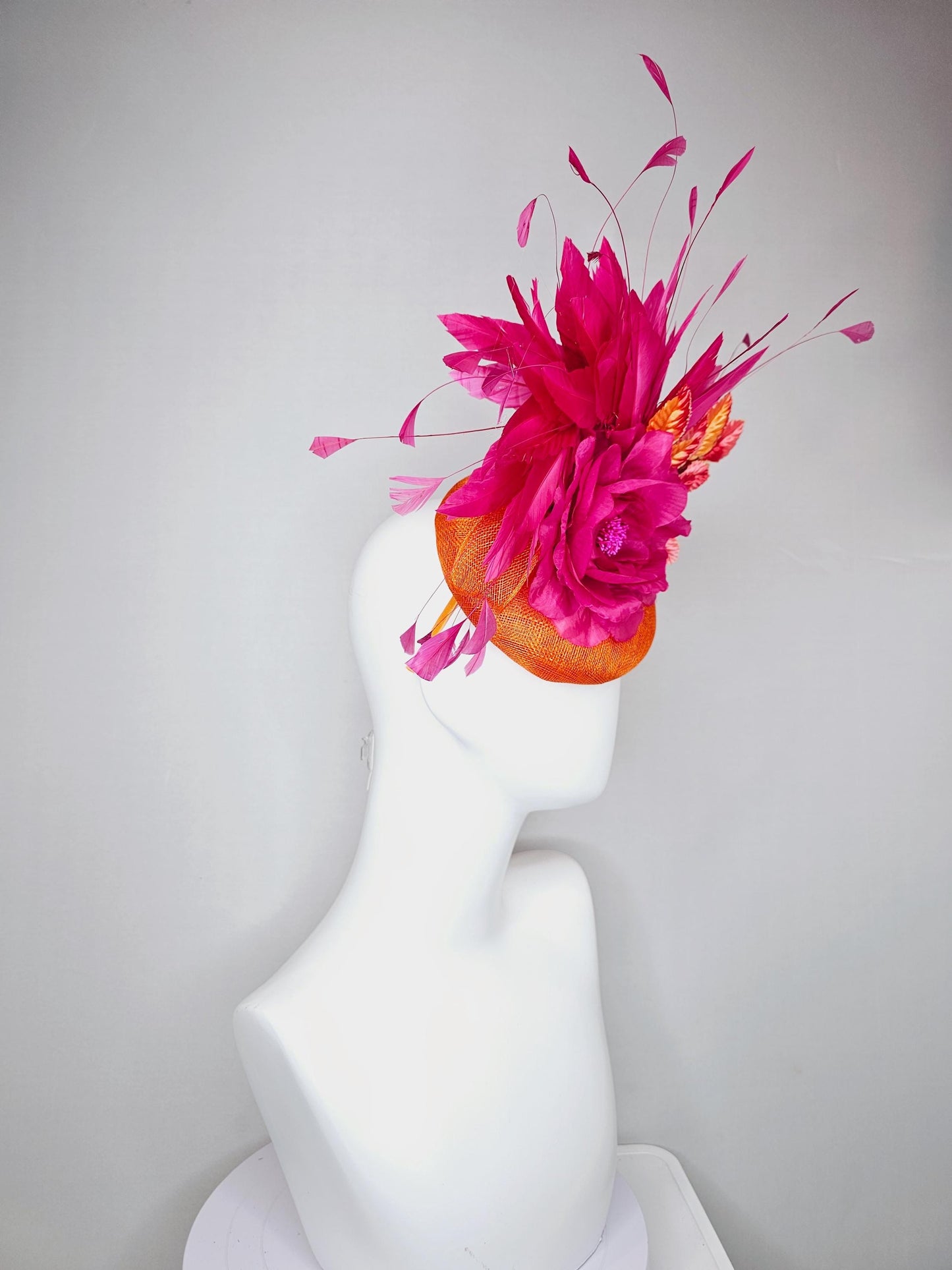 kentucky derby hat fascinator burnt orange sinamay with bright pink satin rose flower, red orange leaves, bright pink branching feathers