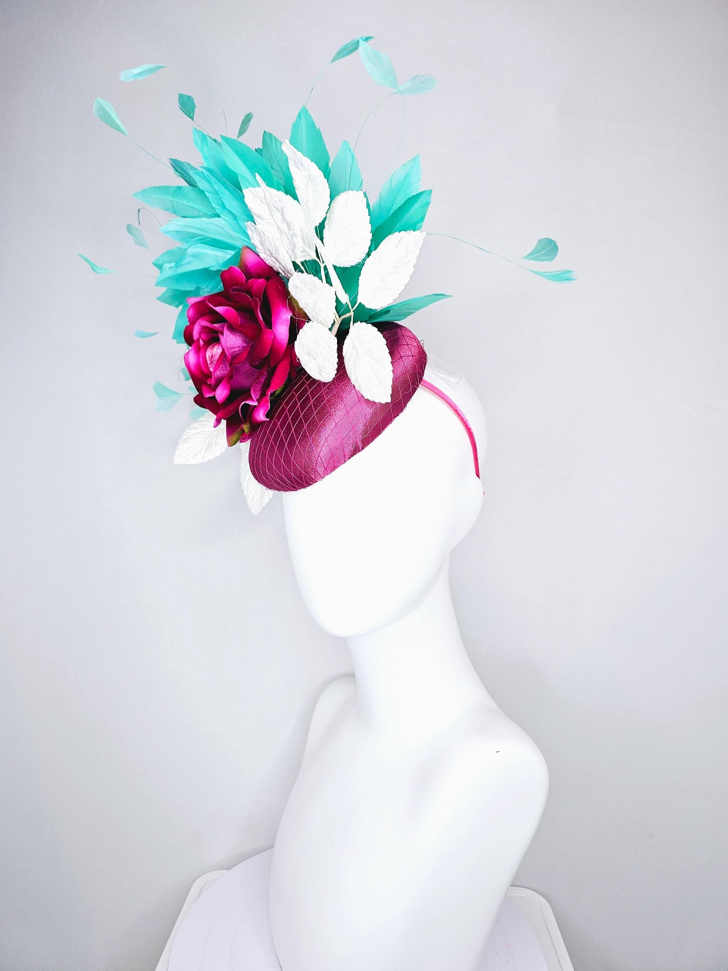 kentucky derby hat fascinator hot pink satin with netting,hot pink fuchsia satin silk rose flower,white leaves,aqua blue branching feathers