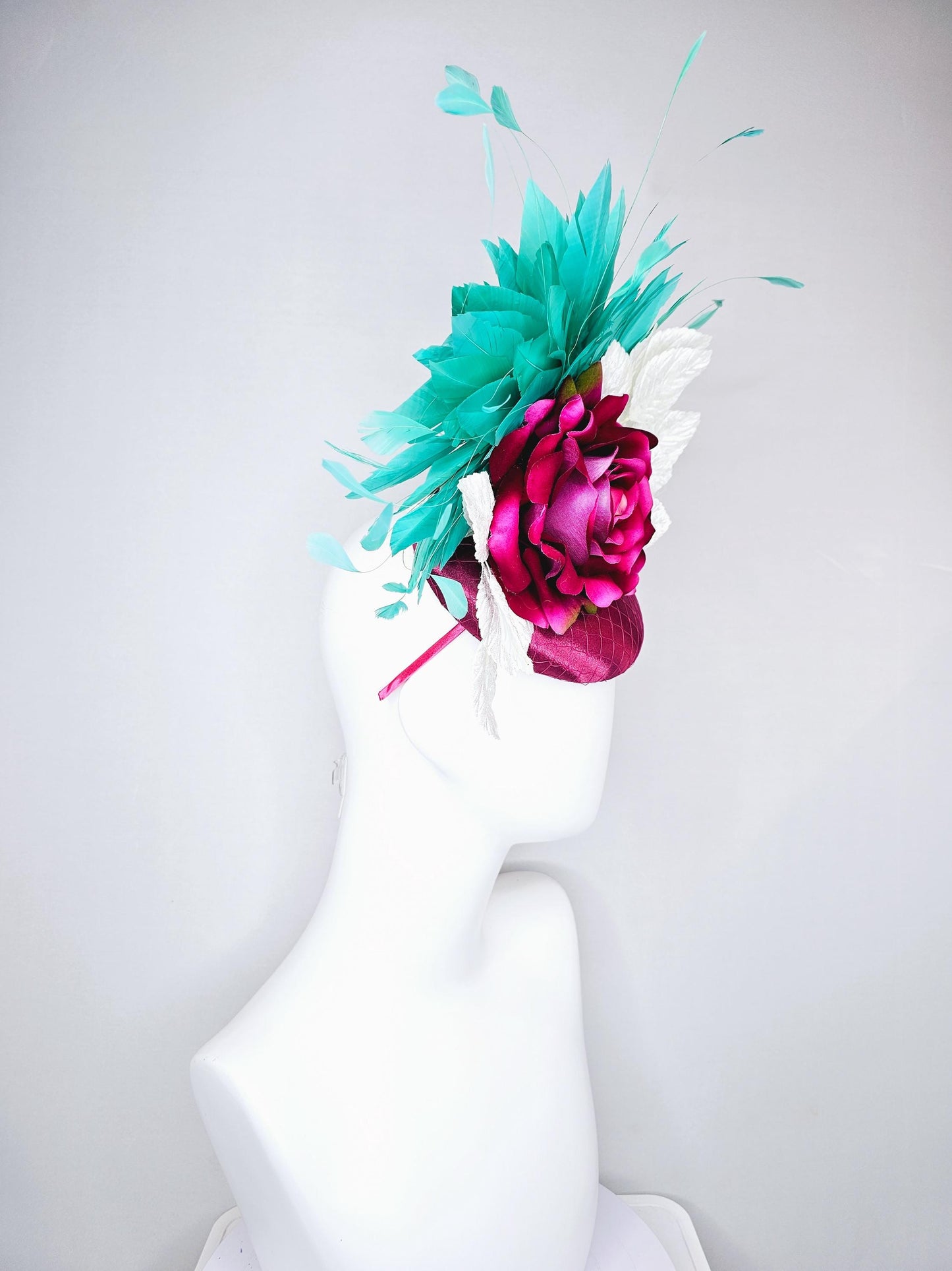 kentucky derby hat fascinator hot pink satin with netting,hot pink fuchsia satin silk rose flower,white leaves,aqua blue branching feathers