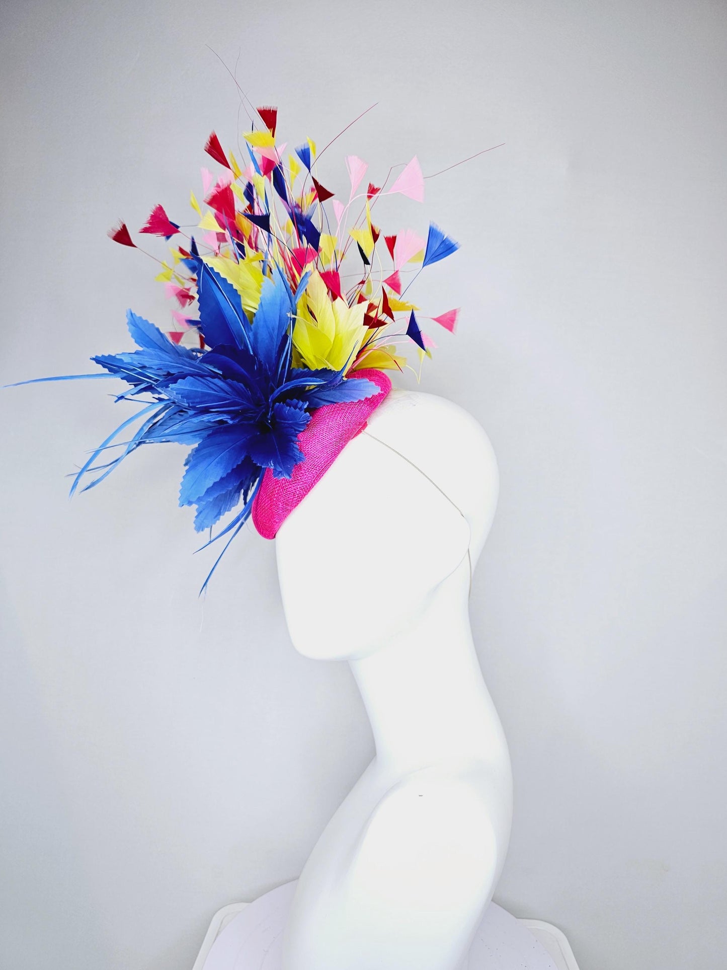 kentucky derby hat fascinator hot pink sinamay with large royal blue feather flower,branching colorful rainbow yellow,blue,red,pink feathers