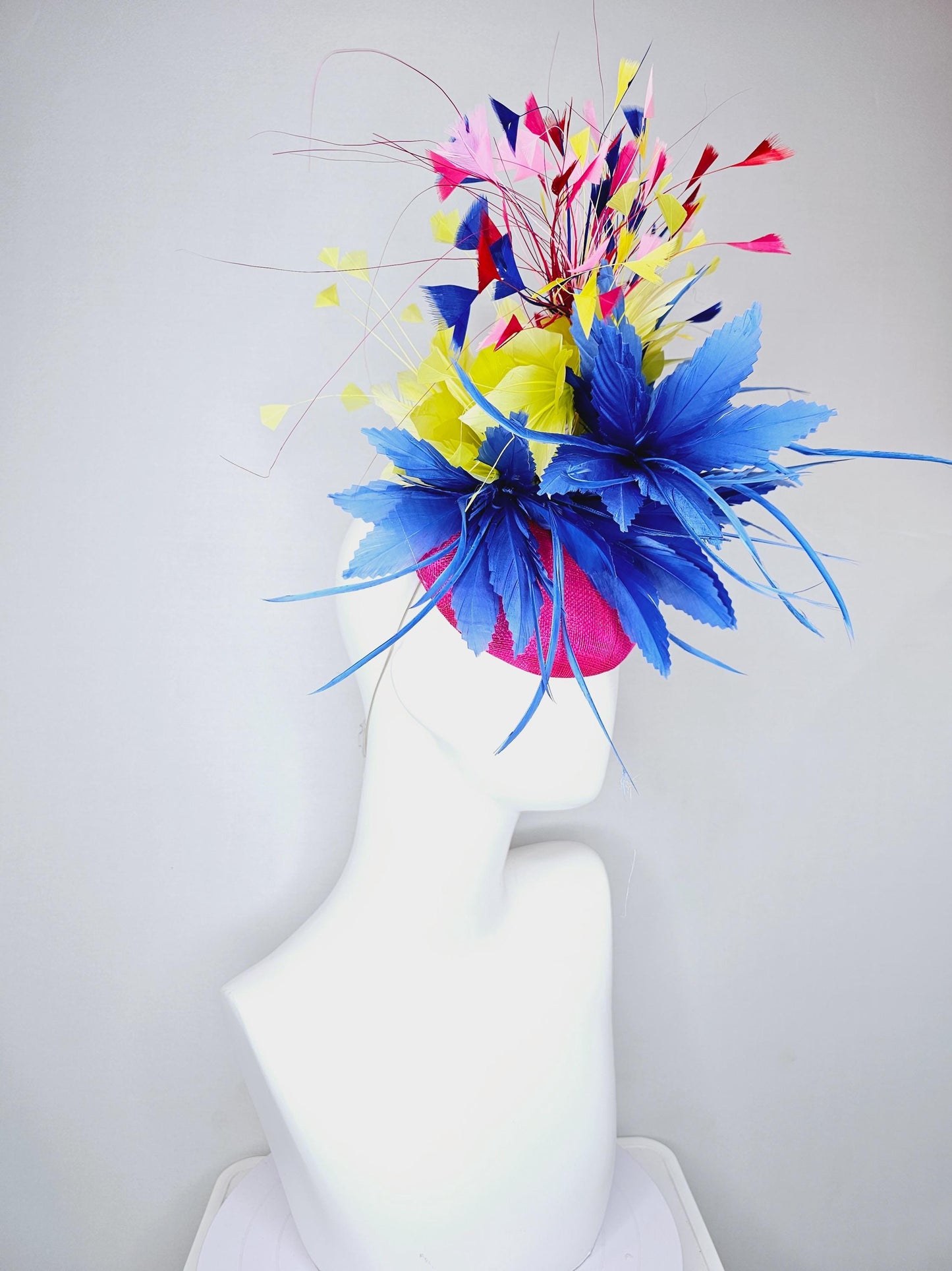 kentucky derby hat fascinator hot pink sinamay with large royal blue feather flower,branching colorful rainbow yellow,blue,red,pink feathers