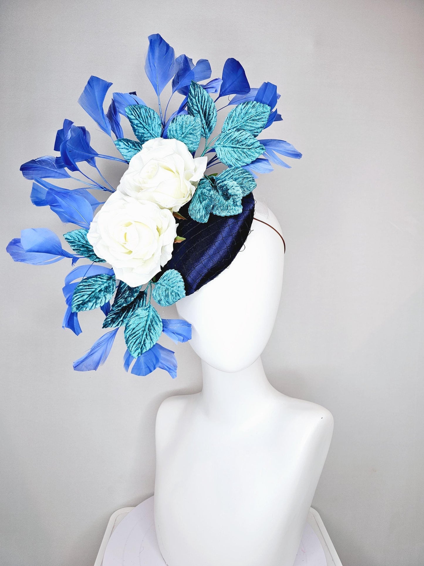 kentucky derby hat fascinator midnight navy blue satin with white silk flowers,teal blue velvet leaves,and royal blue branching feathers