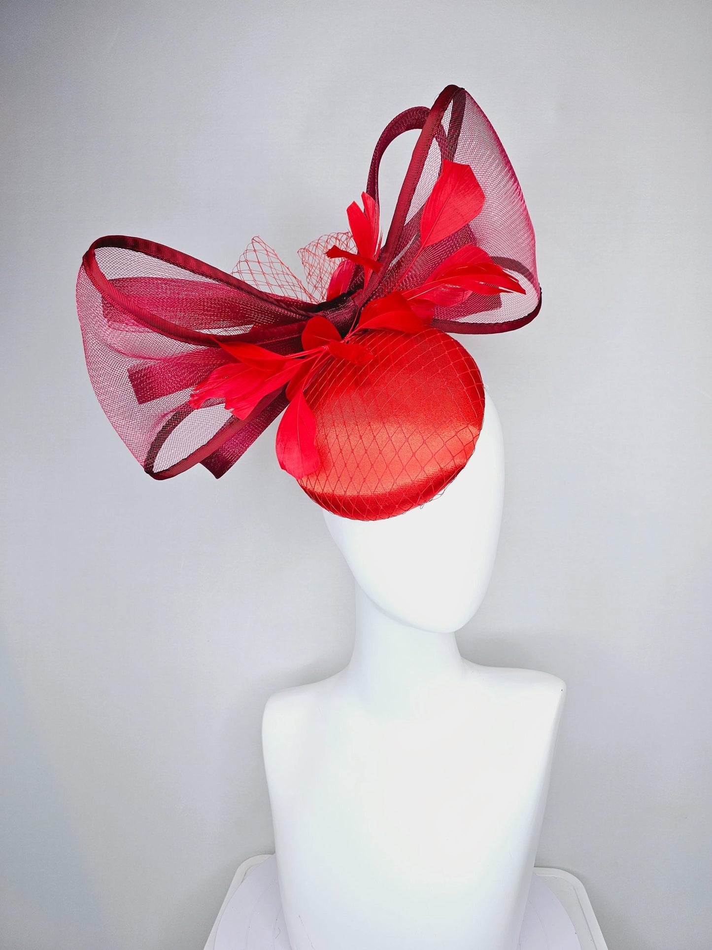 kentucky derby hat fascinator cherry red satin with netting,branching bright red feathers and large mesh burgundy wine bow