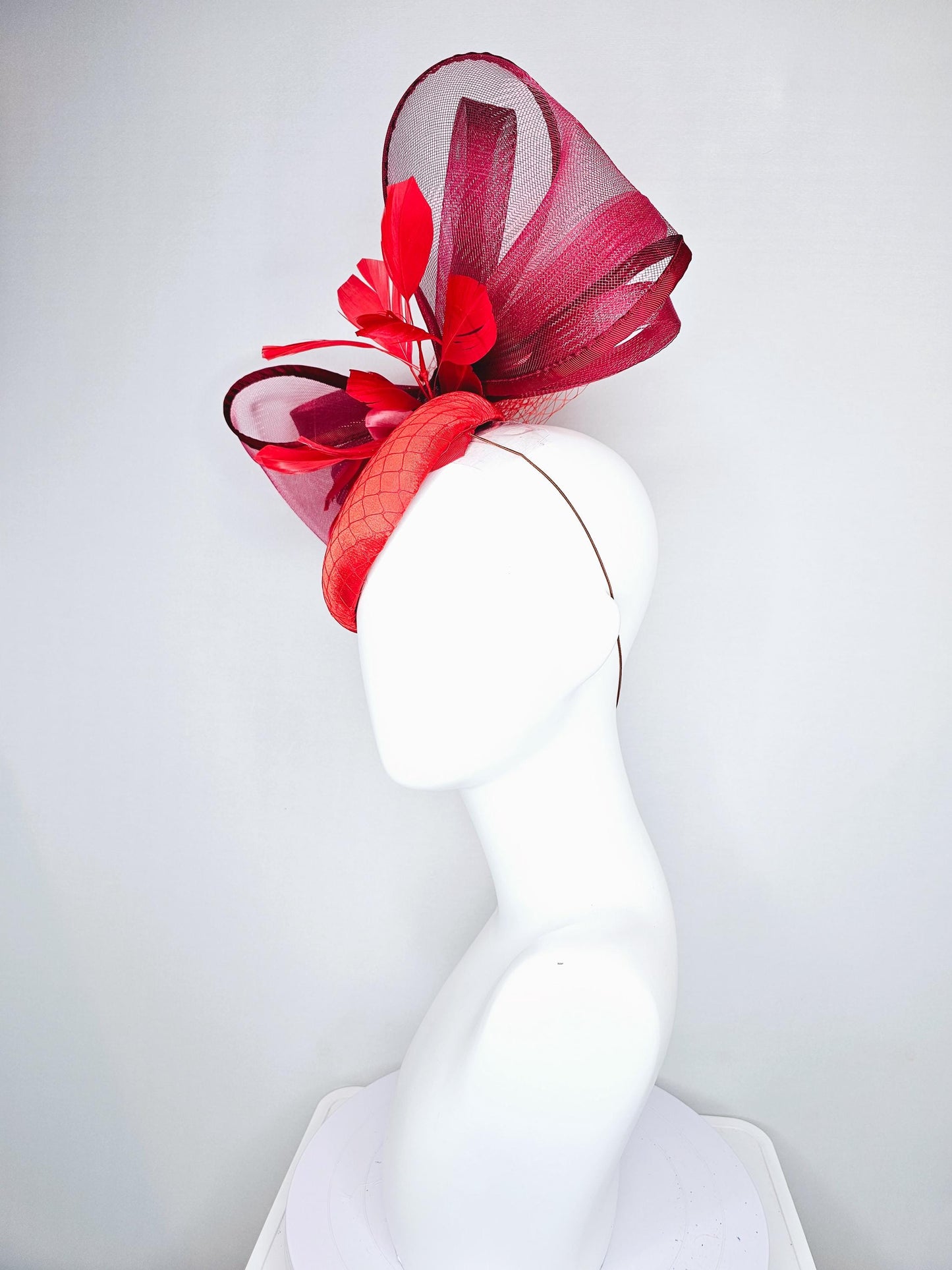 kentucky derby hat fascinator cherry red satin with netting,branching bright red feathers and large mesh burgundy wine bow