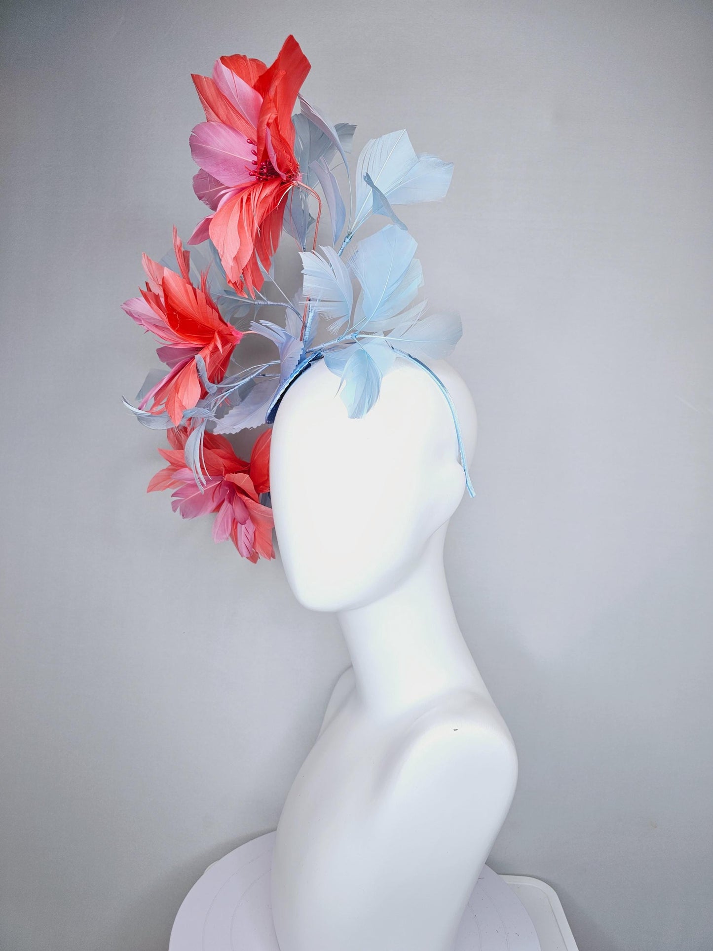 kentucky derby hat fascinator with large coral orange light pink feather flowers and light baby blue branching feathers