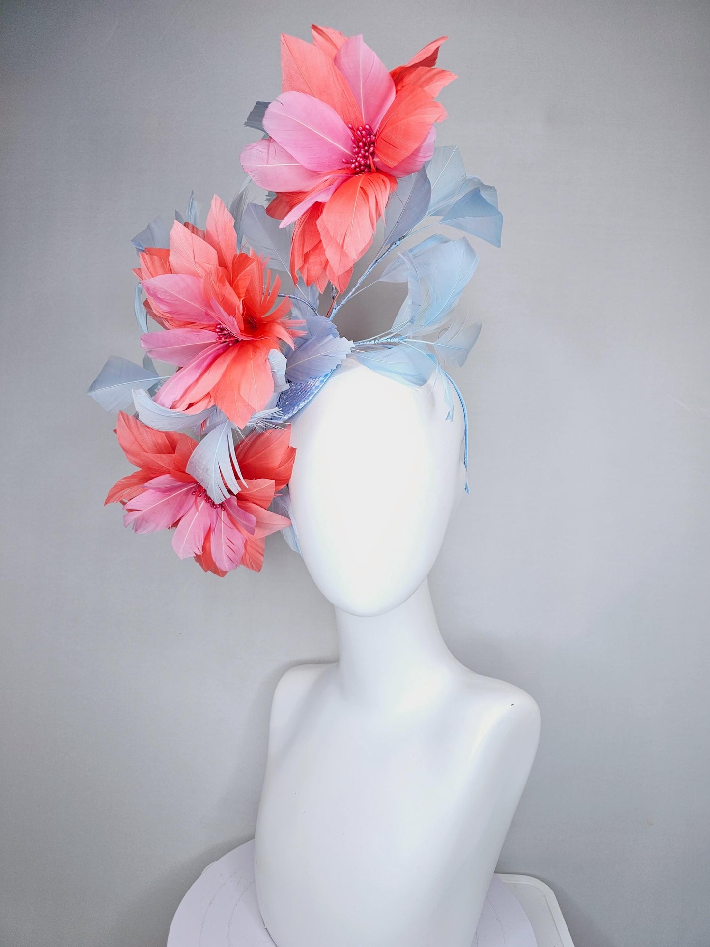 kentucky derby hat fascinator with large coral orange light pink feather flowers and light baby blue branching feathers