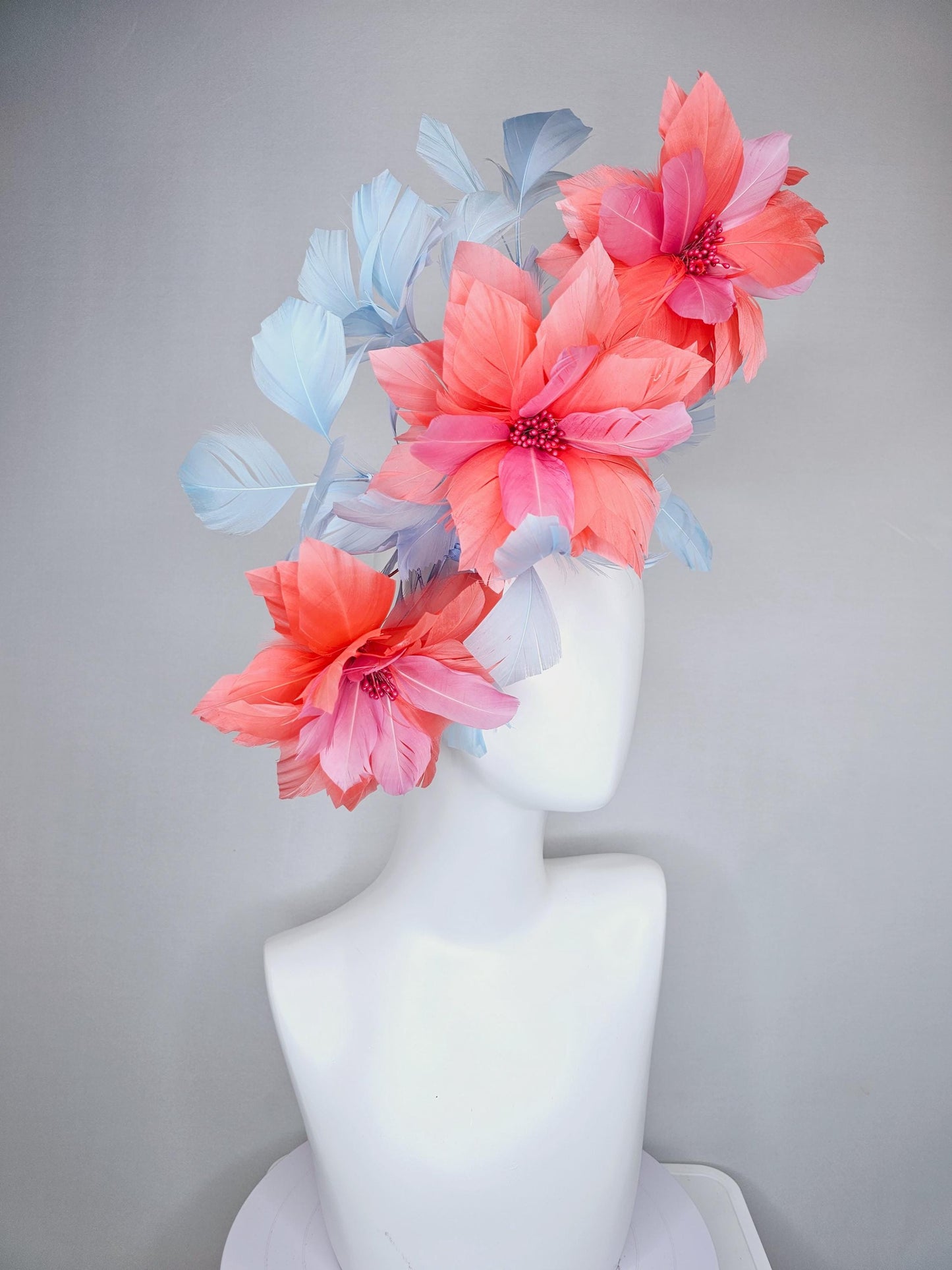 kentucky derby hat fascinator with large coral orange light pink feather flowers and light baby blue branching feathers