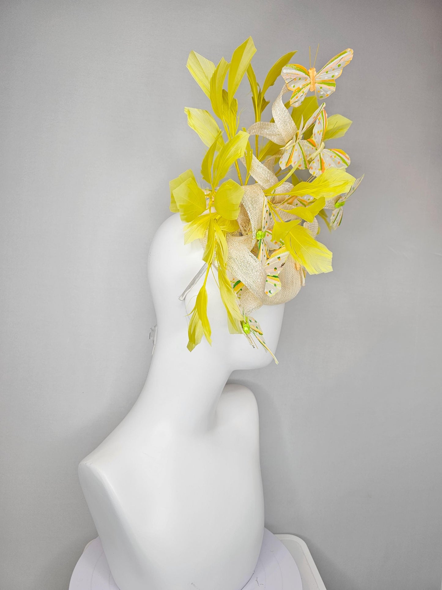 kentucky derby hat fascinator white sinamay with large curls,yellow branching feathers and green,yellow,orange dotted feather butterflies