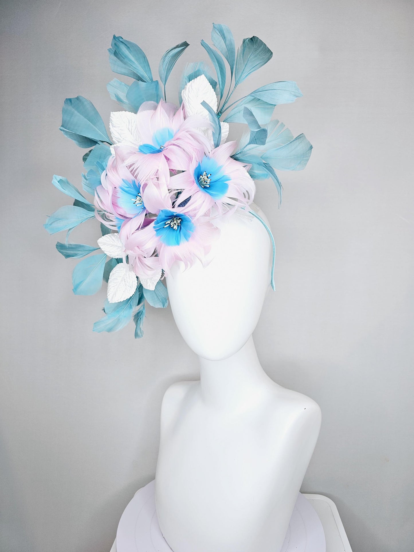 kentucky derby hat fascinator with pale pink feather flowers with sky blue feather cores, white leaves and teal blue branching feathers