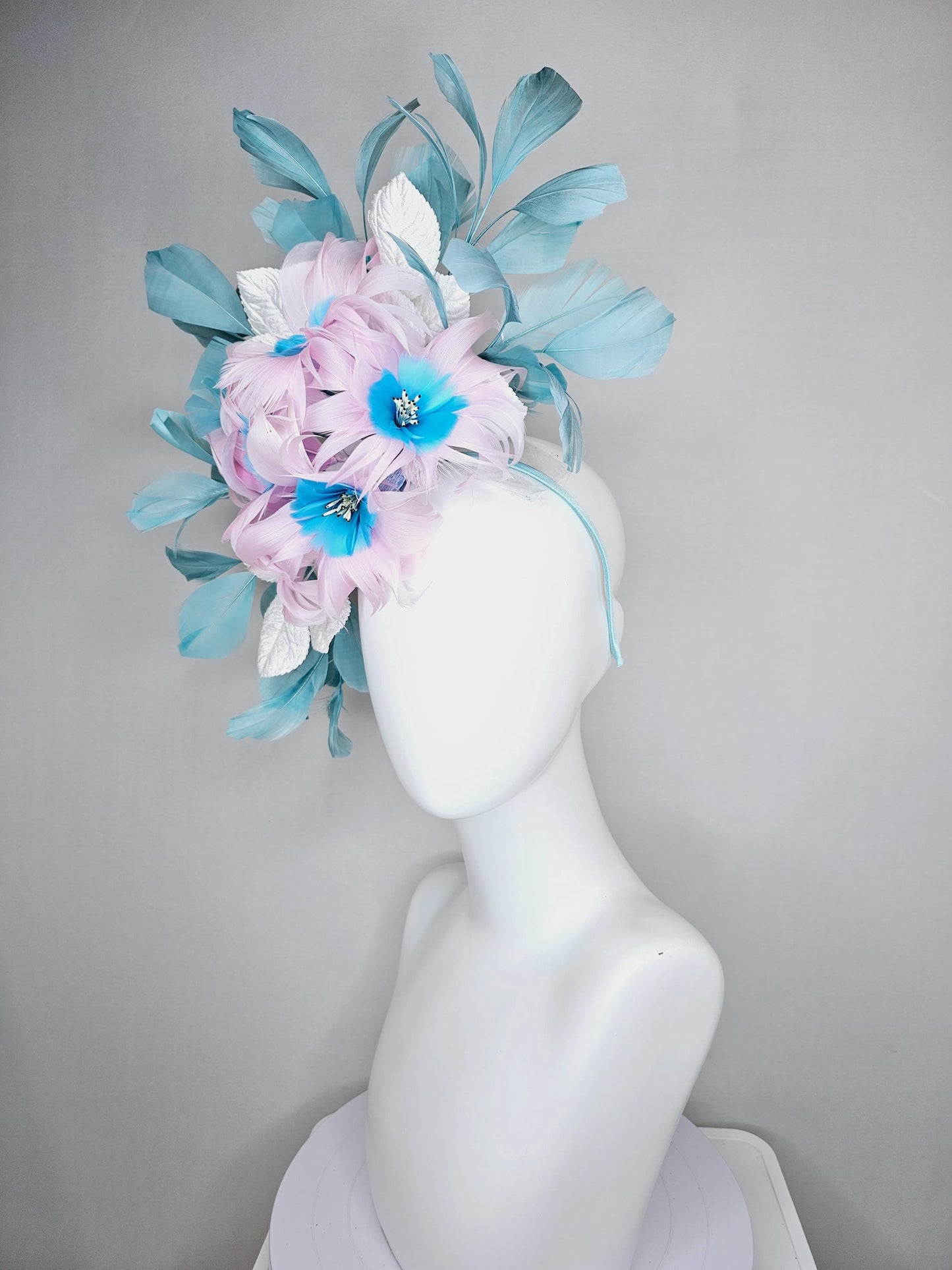 kentucky derby hat fascinator with pale pink feather flowers with sky blue feather cores, white leaves and teal blue branching feathers