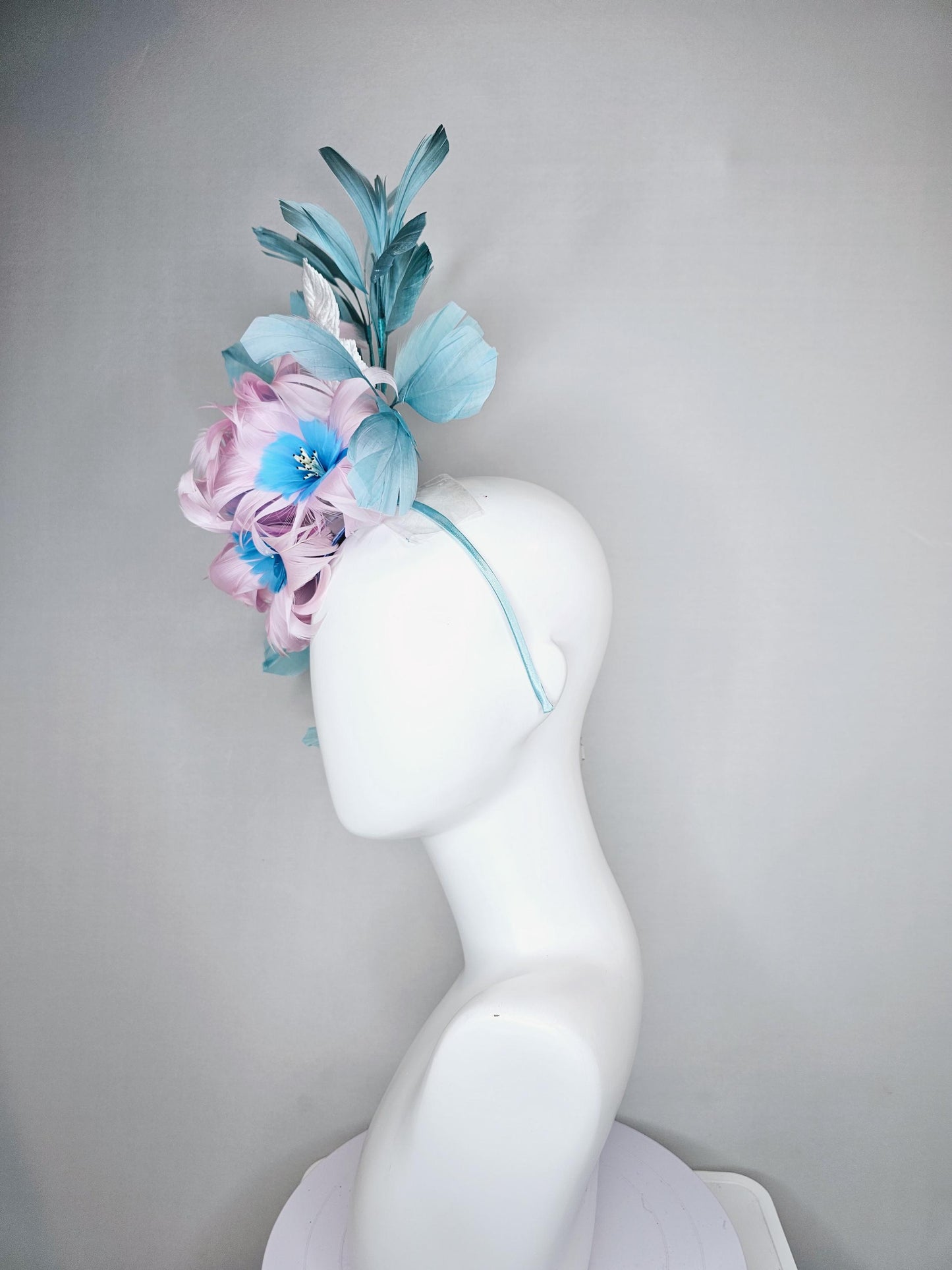 kentucky derby hat fascinator with pale pink feather flowers with sky blue feather cores, white leaves and teal blue branching feathers