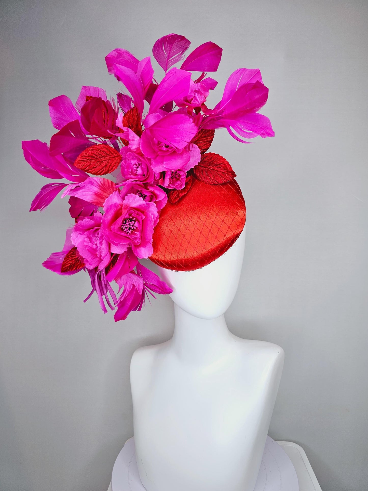 kentucky derby hat fascinator red satin with netting,bright pink fuchsia satin flowers, scarlet red leaves, bright pink branching feathers