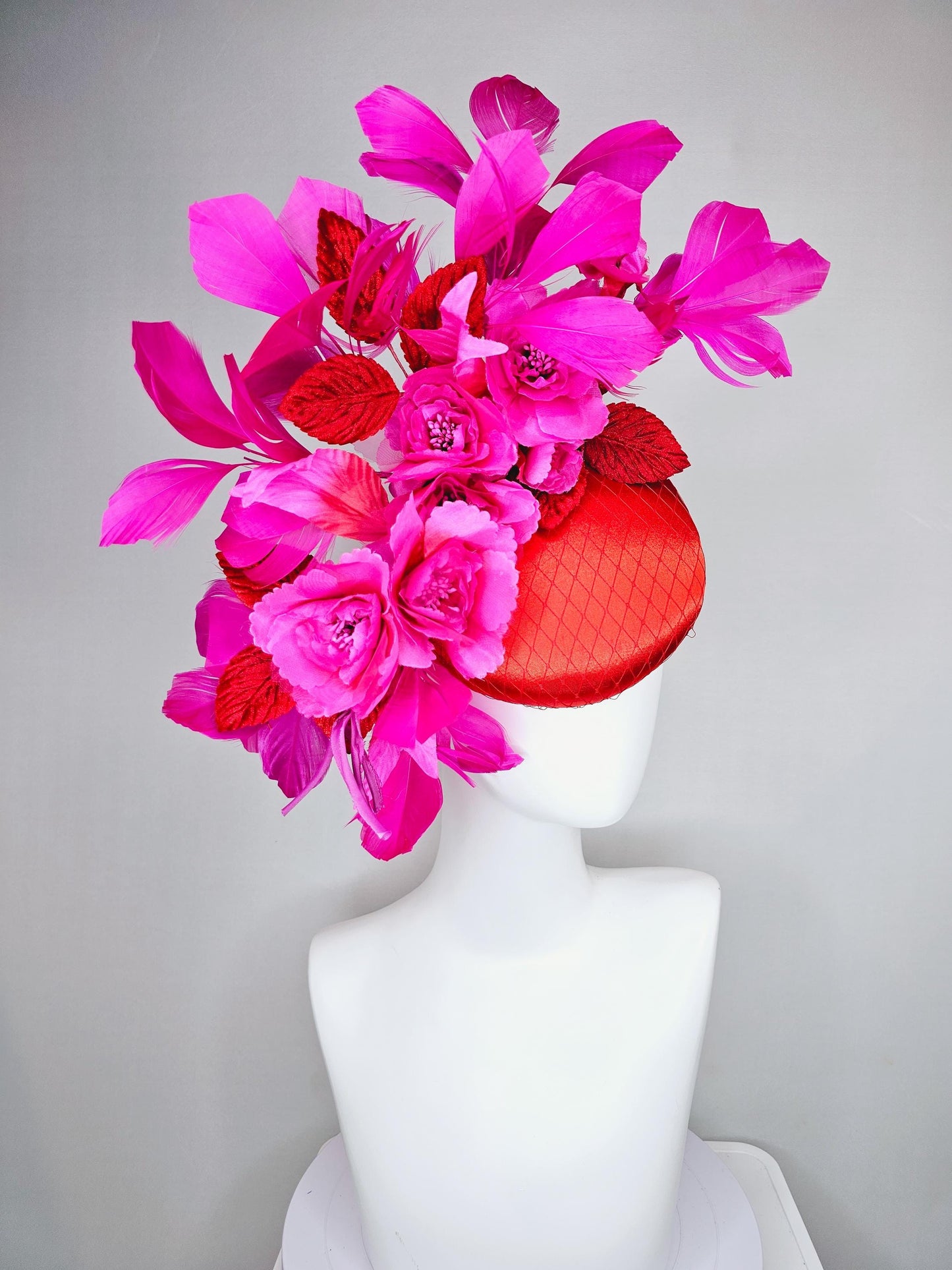 kentucky derby hat fascinator red satin with netting,bright pink fuchsia satin flowers, scarlet red leaves, bright pink branching feathers