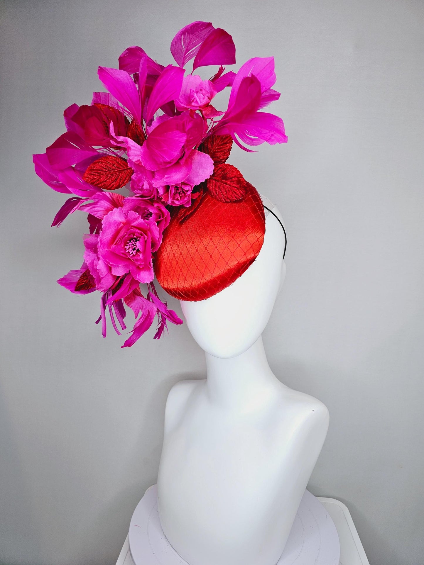 kentucky derby hat fascinator red satin with netting,bright pink fuchsia satin flowers, scarlet red leaves, bright pink branching feathers