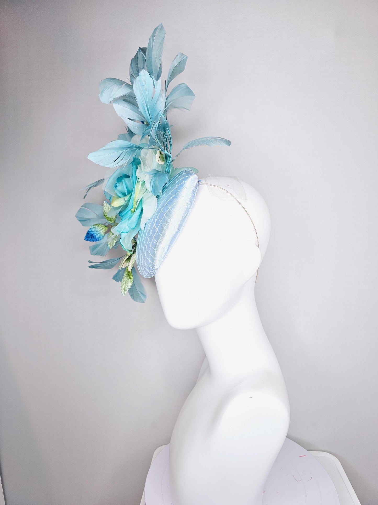 kentucky derby hat fascinator light blue satin with netting, sky blue organza rose flower,blue and green leaves,teal blue branching feathers