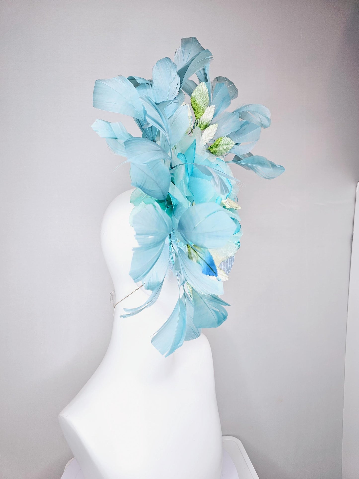 kentucky derby hat fascinator light blue satin with netting, sky blue organza rose flower,blue and green leaves,teal blue branching feathers