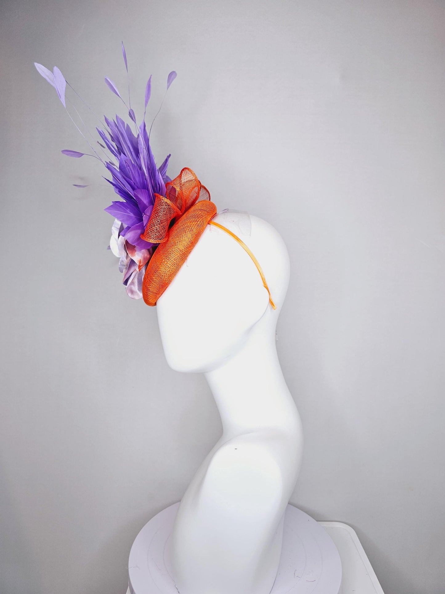 kentucky derby hat fascinator orange sinamay with lavender purple branching feathers and large purple and orange tie dye satin rose flower