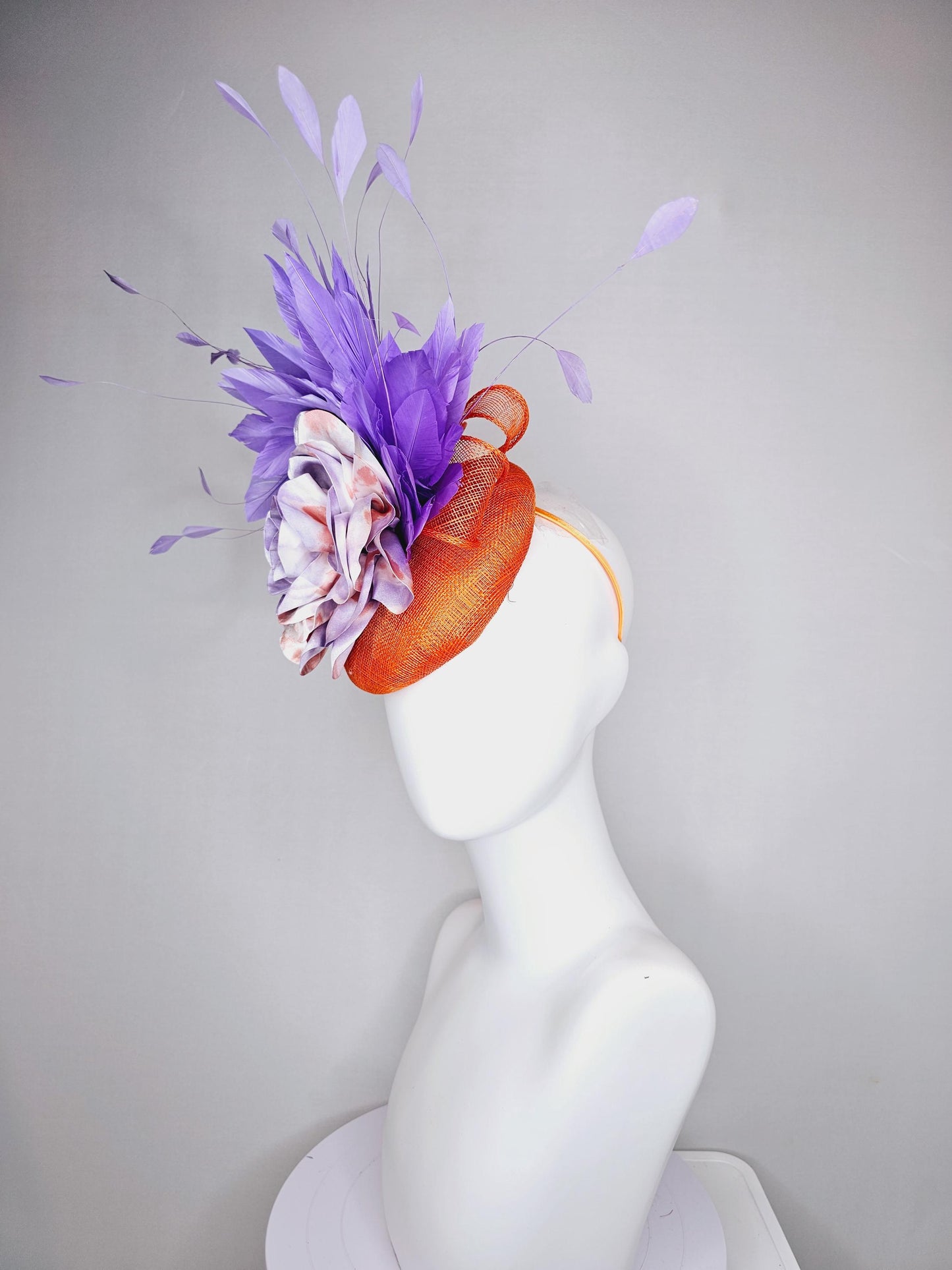 kentucky derby hat fascinator orange sinamay with lavender purple branching feathers and large purple and orange tie dye satin rose flower