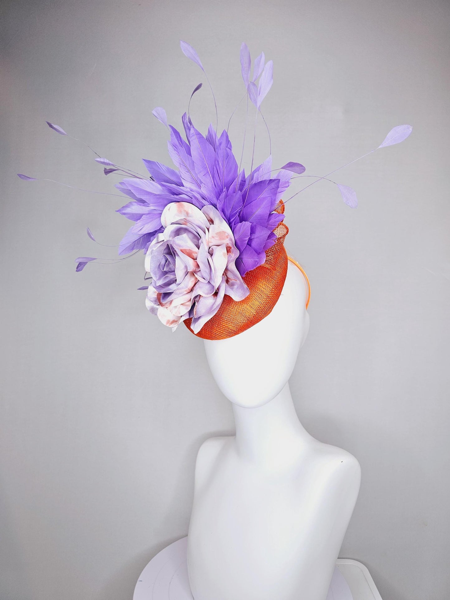 kentucky derby hat fascinator orange sinamay with lavender purple branching feathers and large purple and orange tie dye satin rose flower