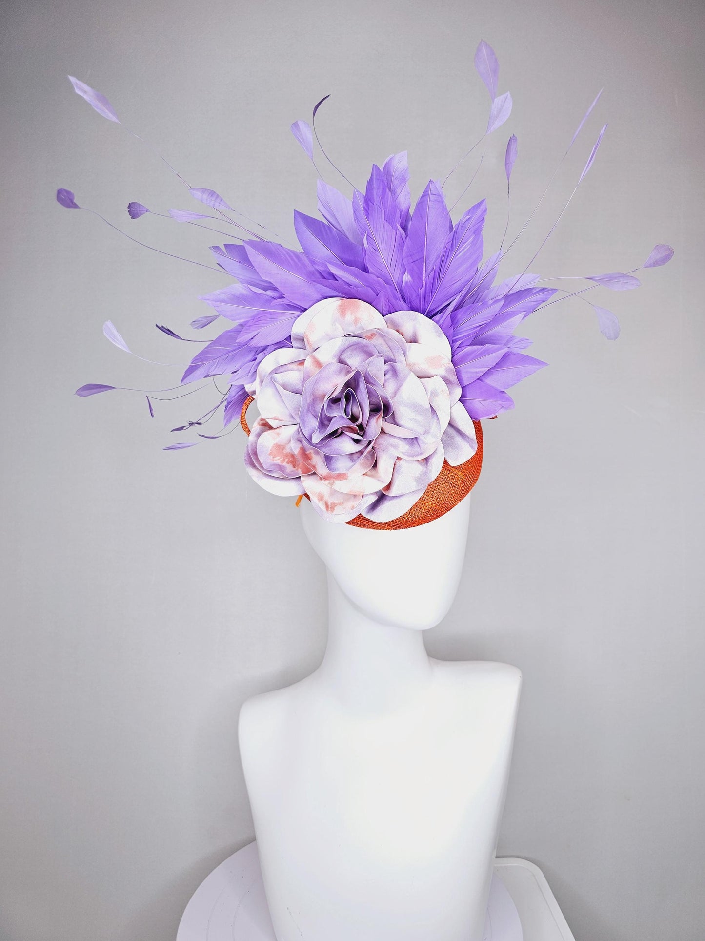 kentucky derby hat fascinator orange sinamay with lavender purple branching feathers and large purple and orange tie dye satin rose flower