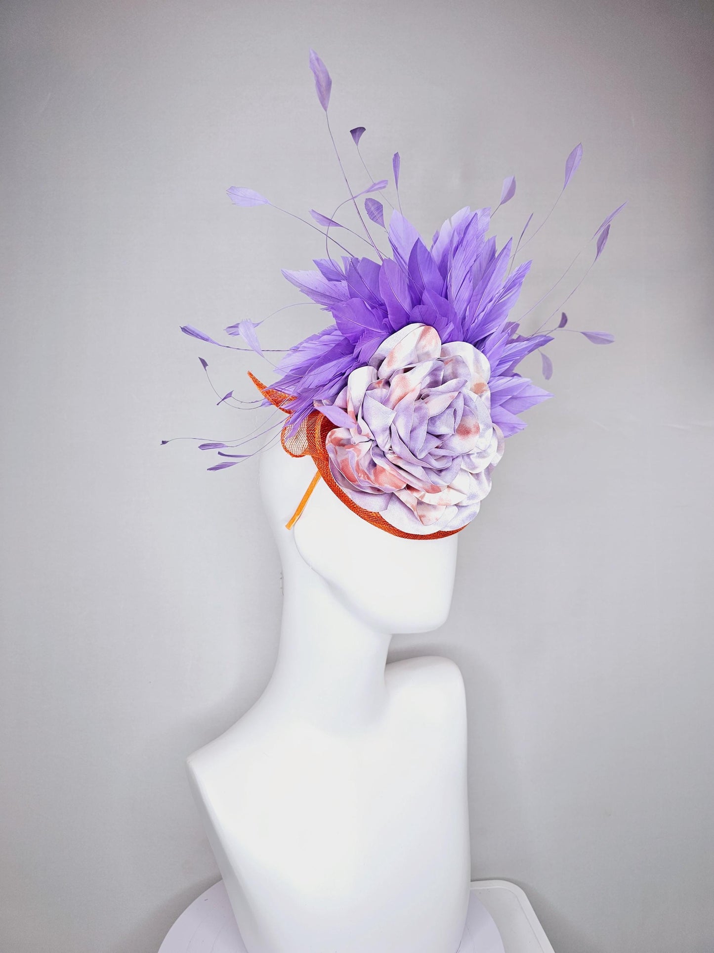 kentucky derby hat fascinator orange sinamay with lavender purple branching feathers and large purple and orange tie dye satin rose flower