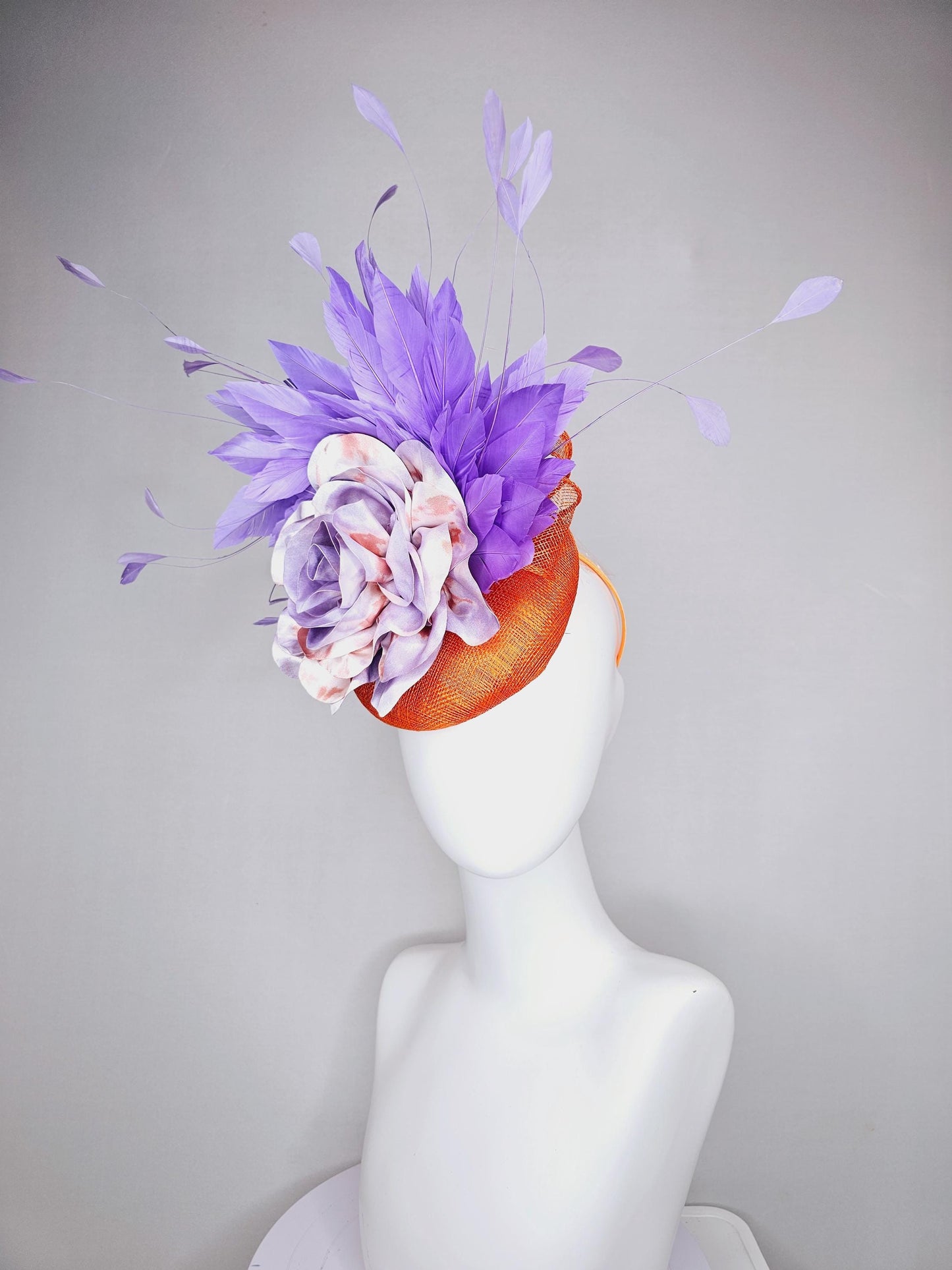 kentucky derby hat fascinator orange sinamay with lavender purple branching feathers and large purple and orange tie dye satin rose flower