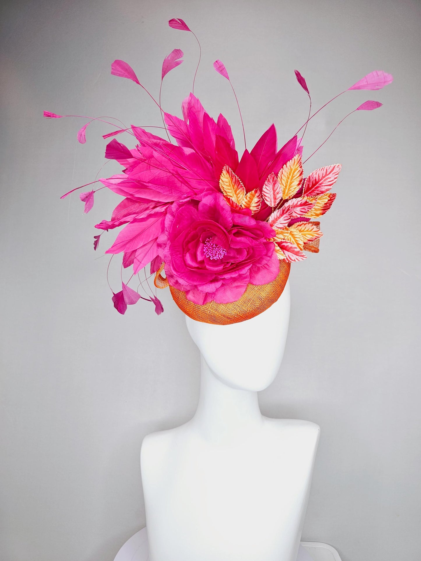 kentucky derby hat fascinator burnt orange sinamay with bright pink satin rose flower, red orange leaves, bright pink branching feathers