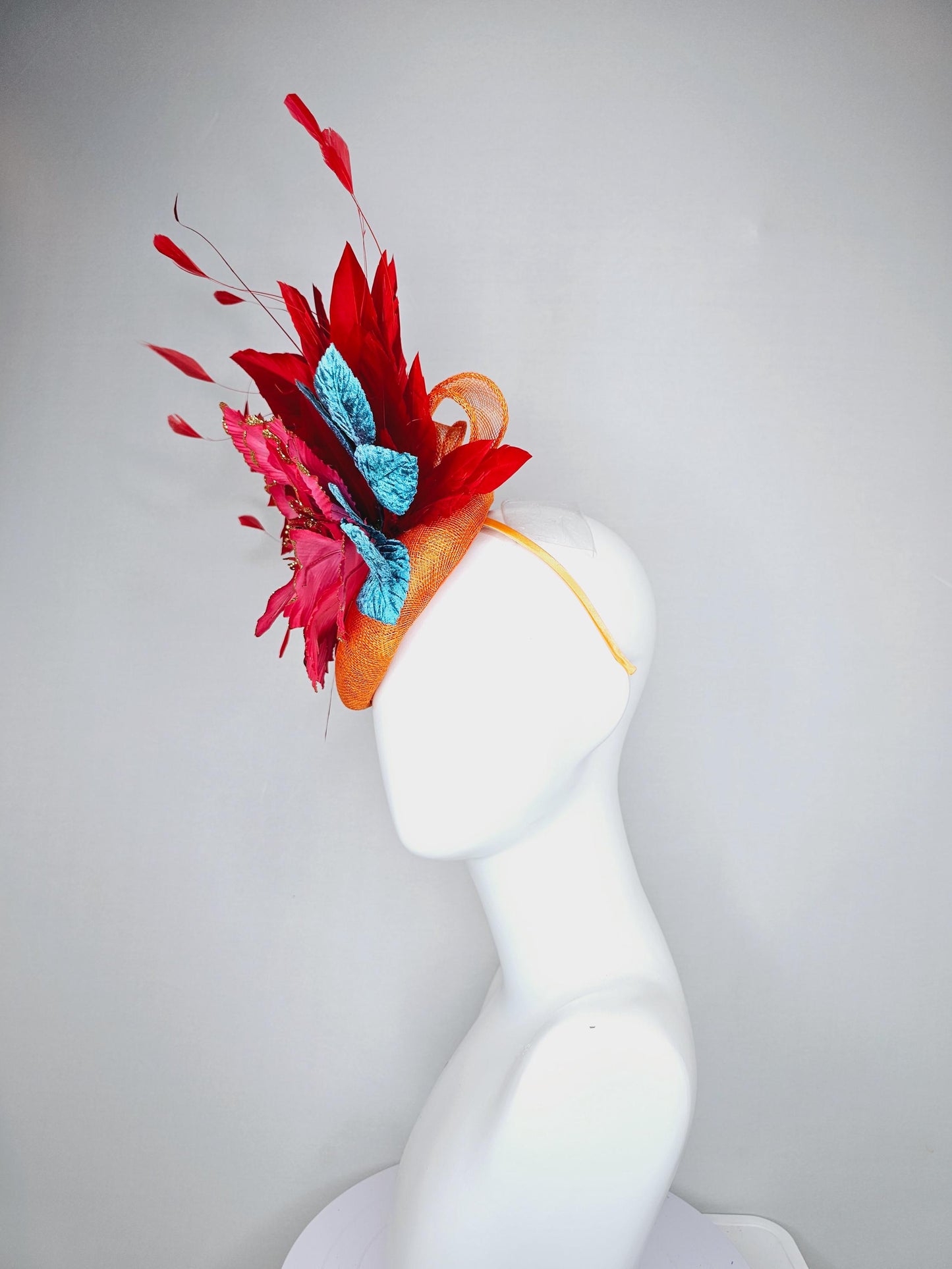 kentucky derby hat fascinator burnt orange sinamay with scarlet red branching feathers, large ombre cherry red satin flower,teal blue leaves