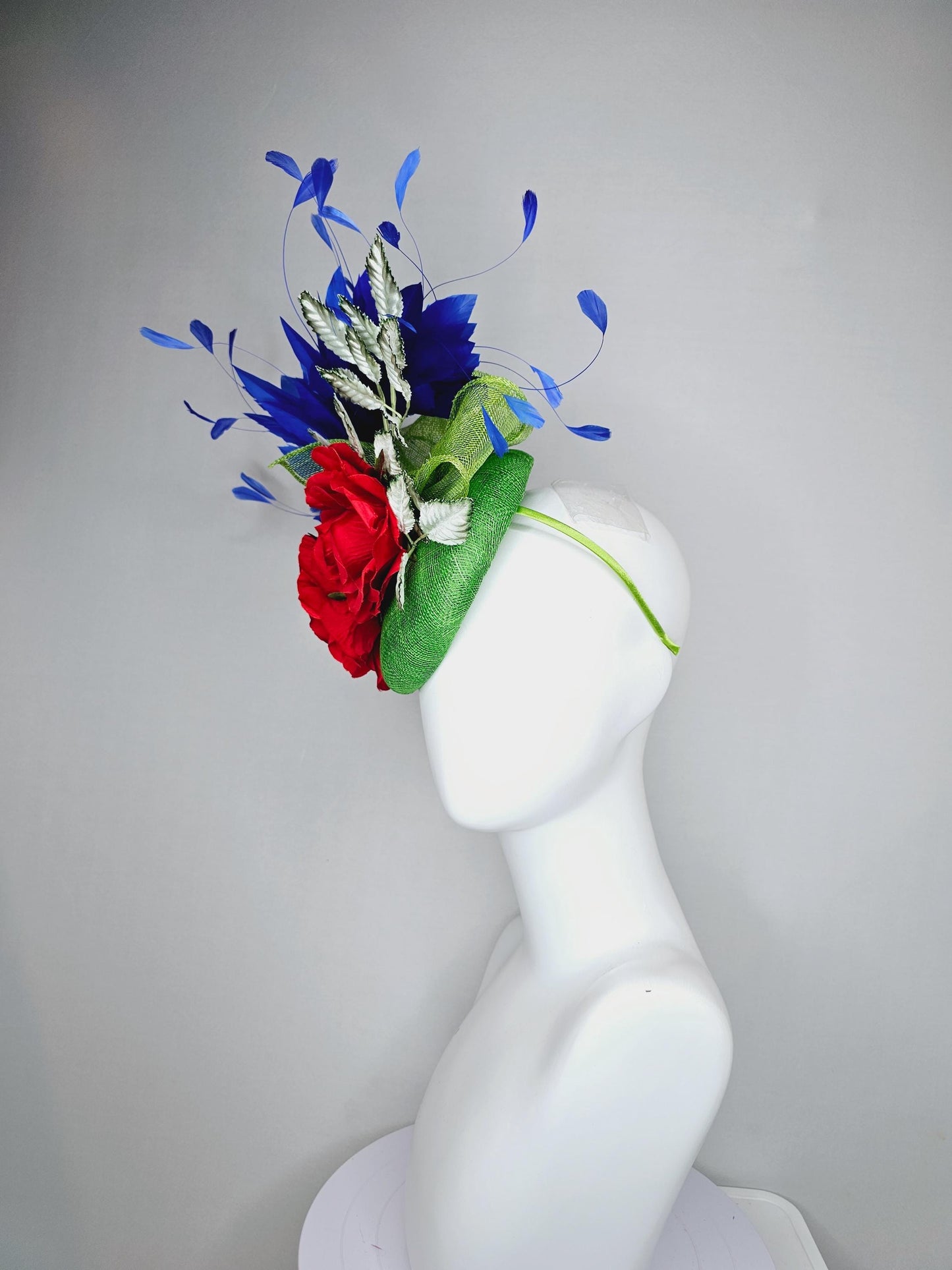 kentucky derby hat fascinator green sinamay with royal blue branching feathers,light green ombre leaves and bright red satin silk roses