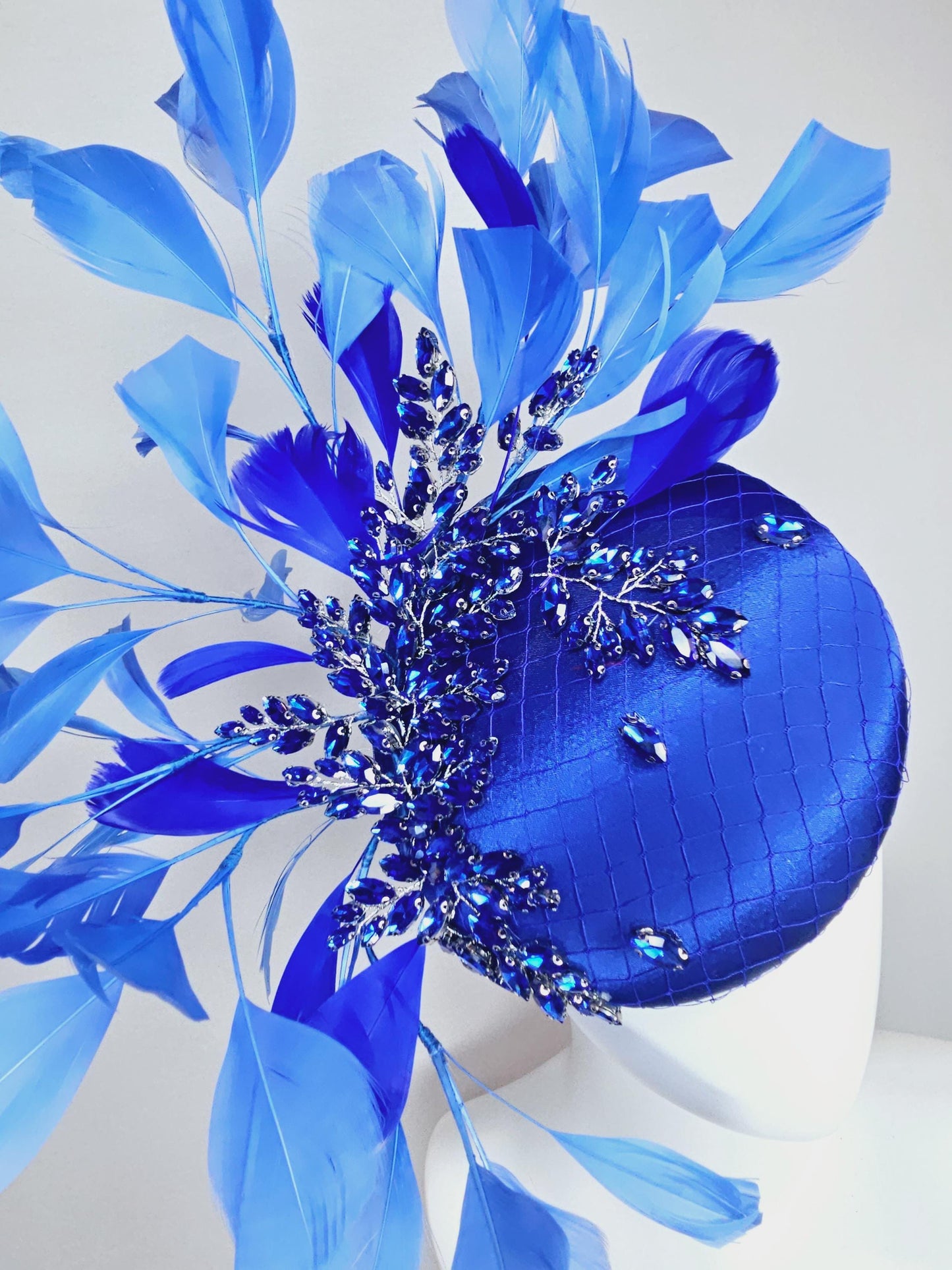 kentucky derby hat fascinator royal blue satin with netting and royal blue crystal beaded jewels stems, royal cobalt blue branching feathers