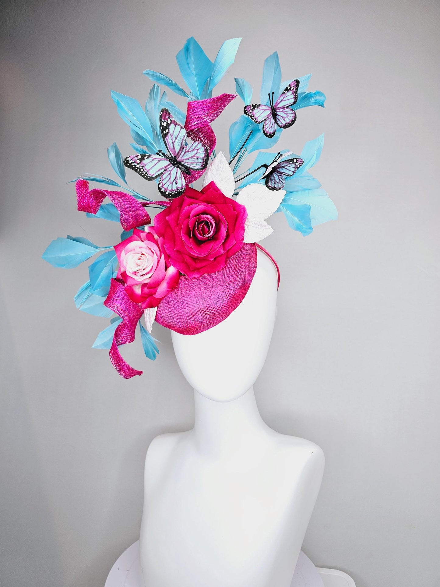 kentucky derby hat fascinator fuchsia pink sinamay with curls,ombre fuchsia pink satin roses,white leaves,sky blue feathers,blue butterflies